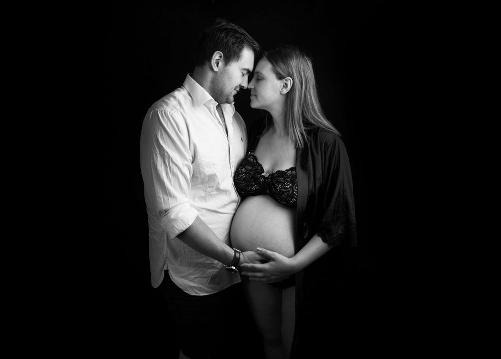 Romantic black and white couple portraits showing intimate moments in low key lighting.