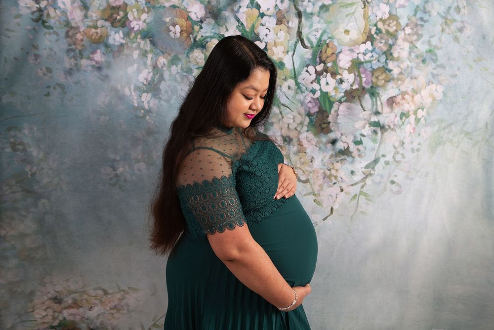 Maternity photos against floral backdrop showing tender moments and embraces.