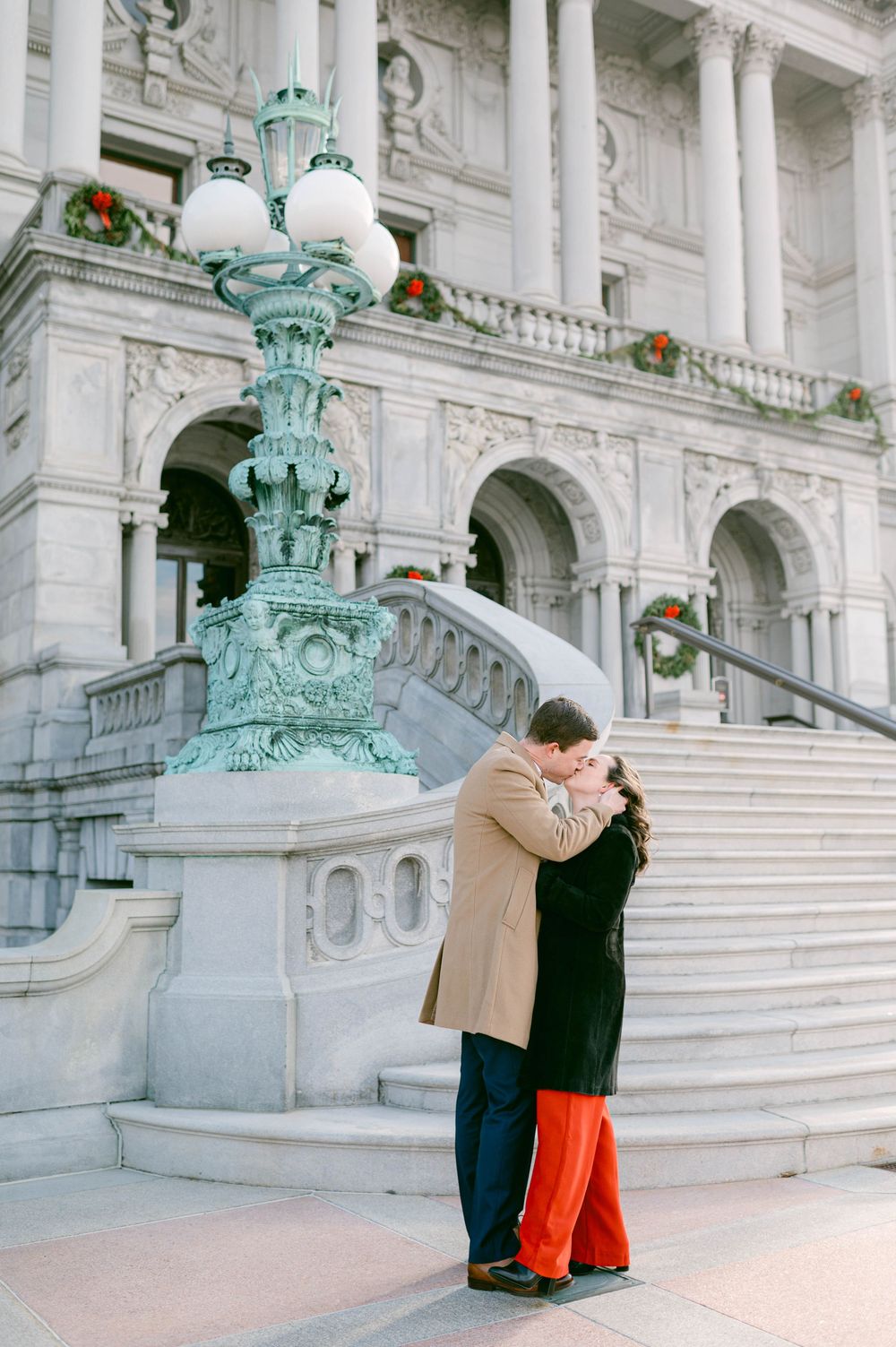 A romantic moment captured on ornate marble steps with decorative turquoise lamp post.