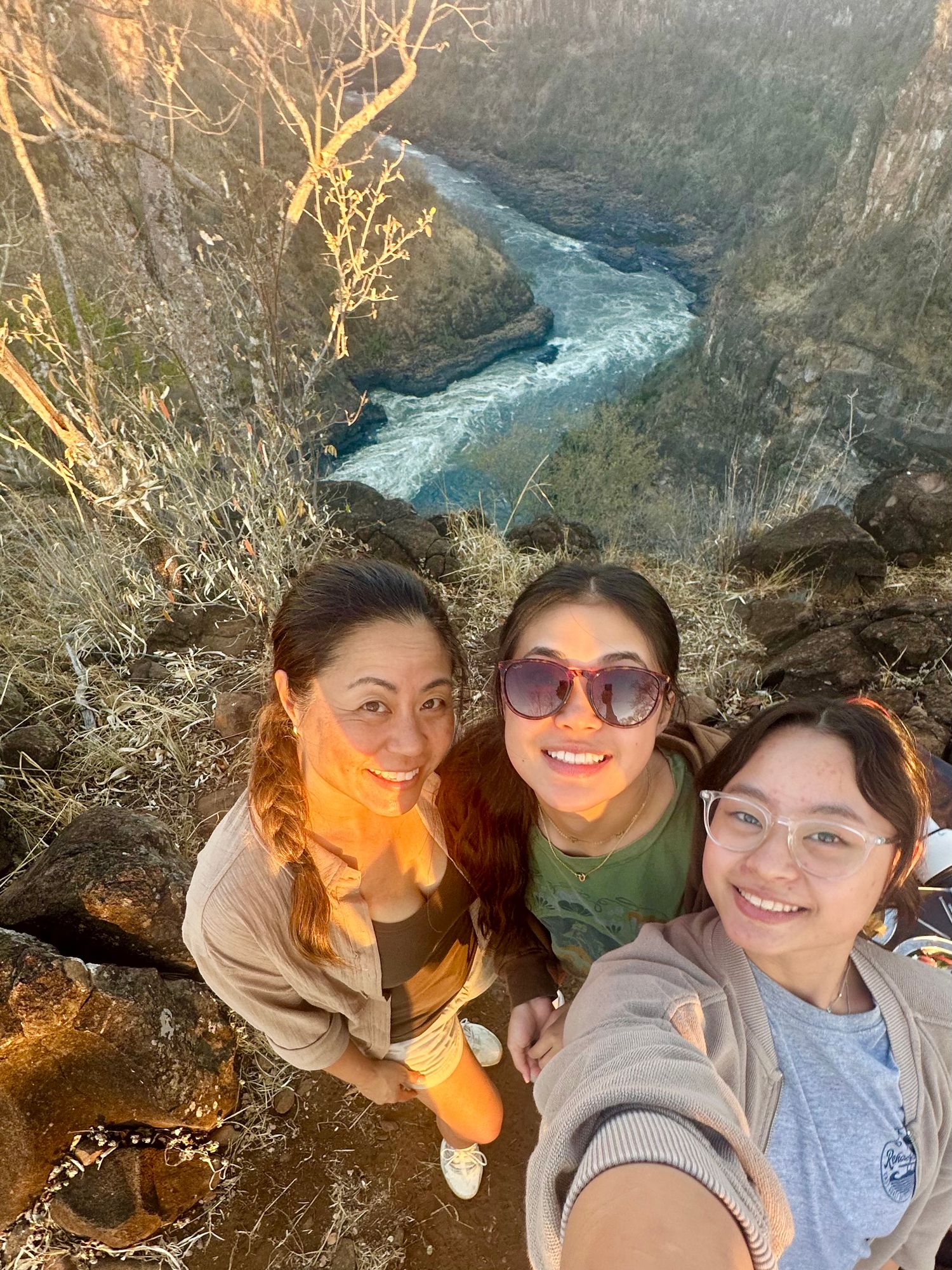 Friends enjoying scenic views of a winding river canyon during golden hour.