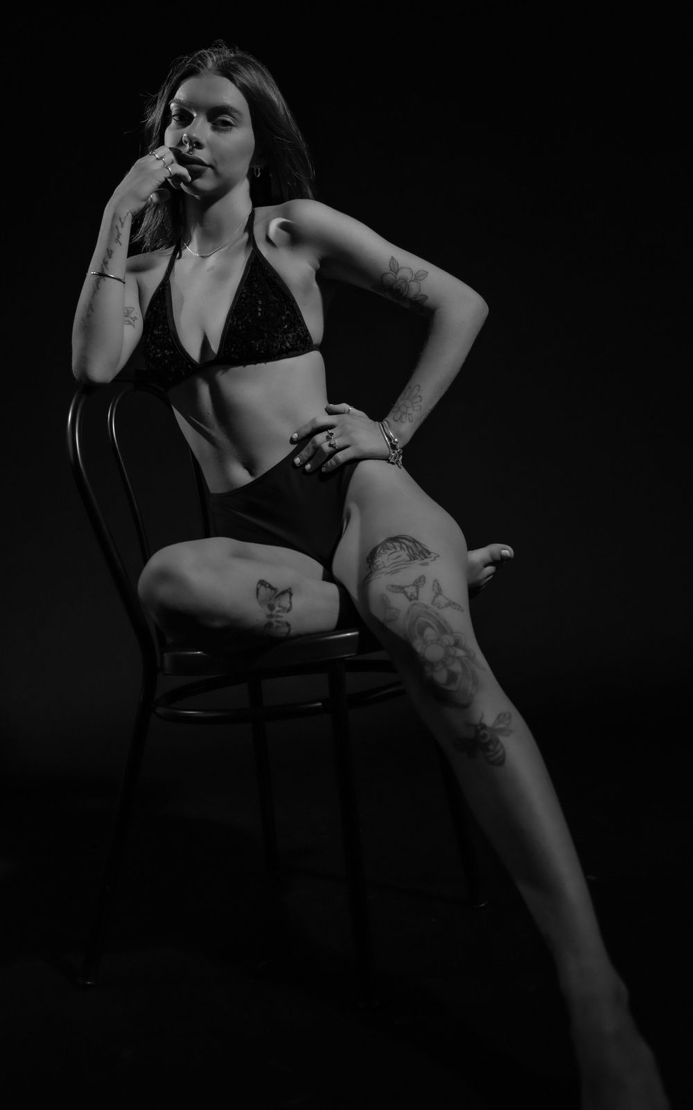 Artistic boudoir photograph featuring dramatic poses and tattoos in black and white.