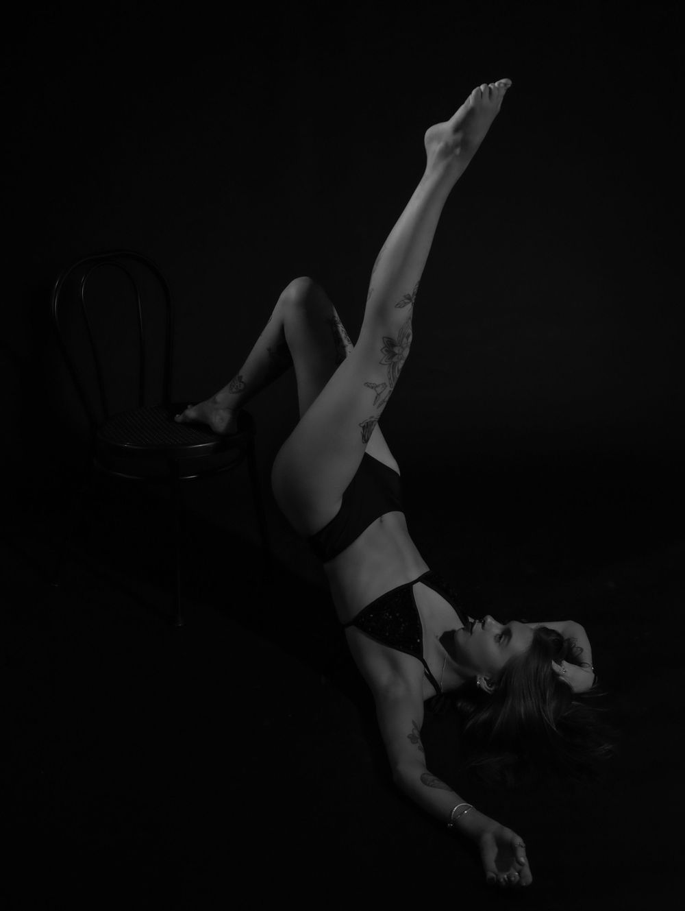 Artistic black and white photograph capturing dynamic movement and graceful pose.