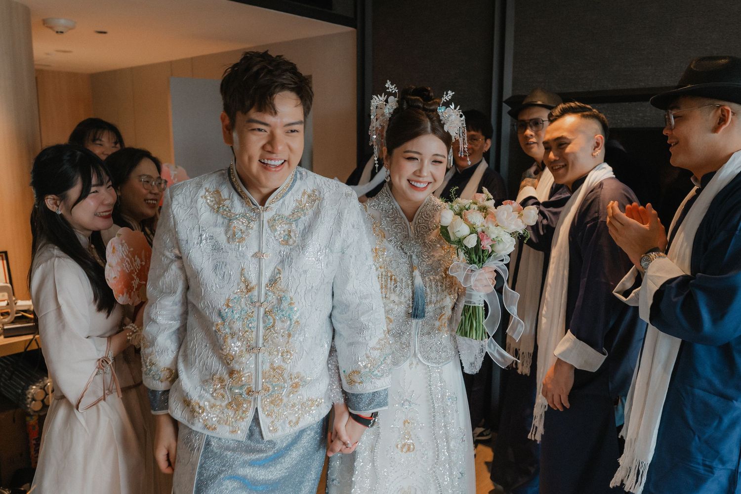 Wedding party members celebrate indoors with joyful expressions and formal attire.