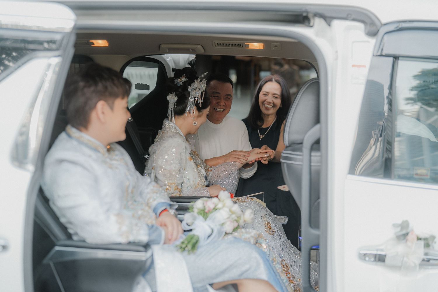 Passengers share a joyful moment inside a vehicle during a special occasion.