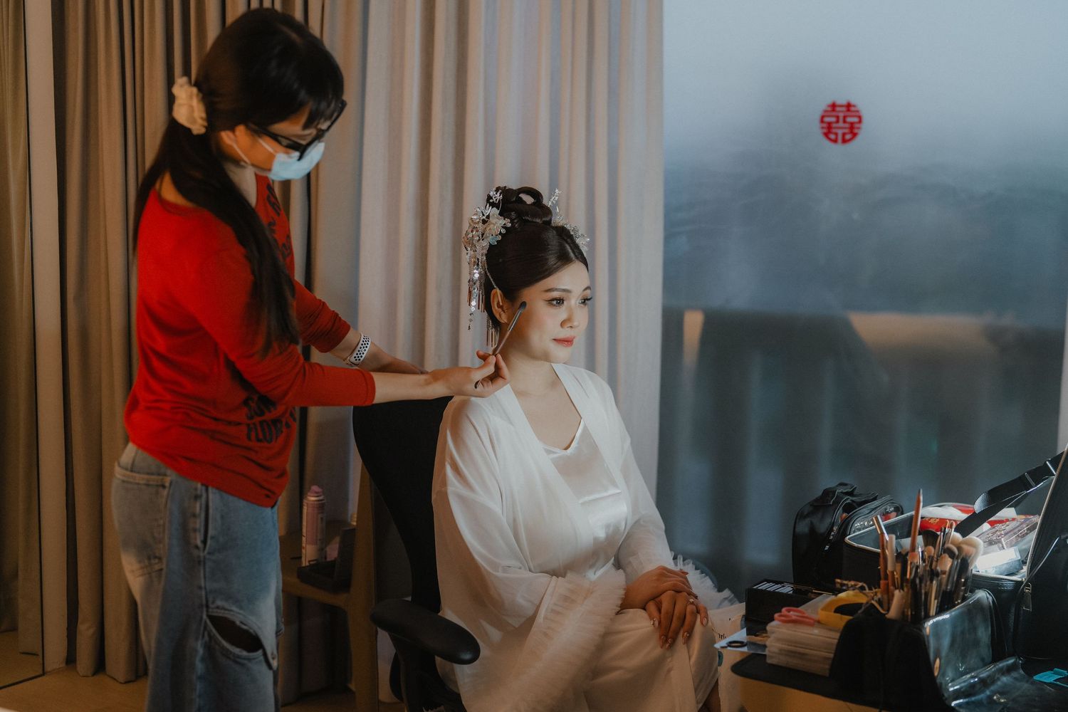 Elegant interior room with curtains and soft lighting during wedding preparation.