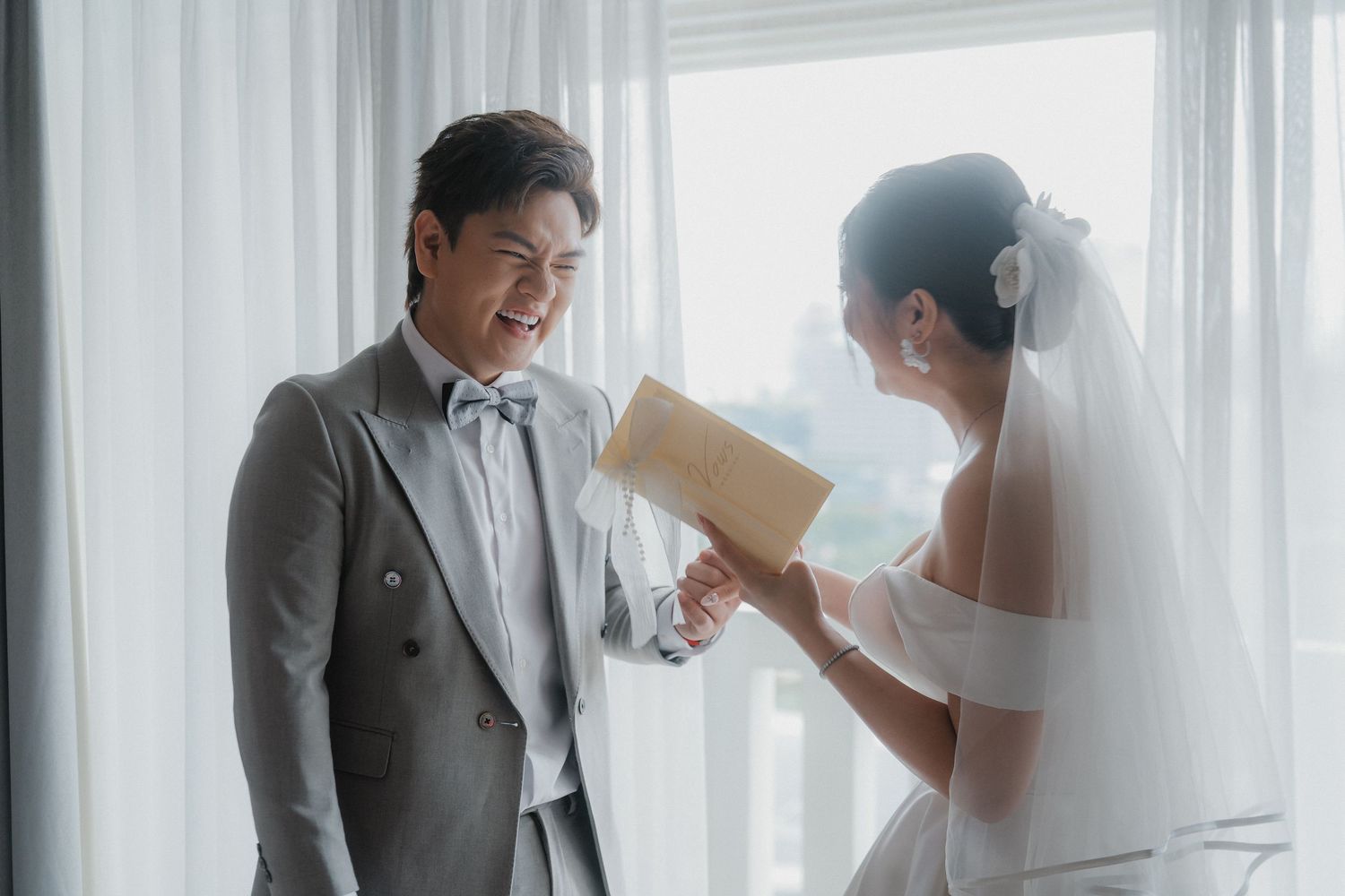 Modern minimalist wedding photos showing tender emotional moments between bride and groom in sunlit indoor setting.