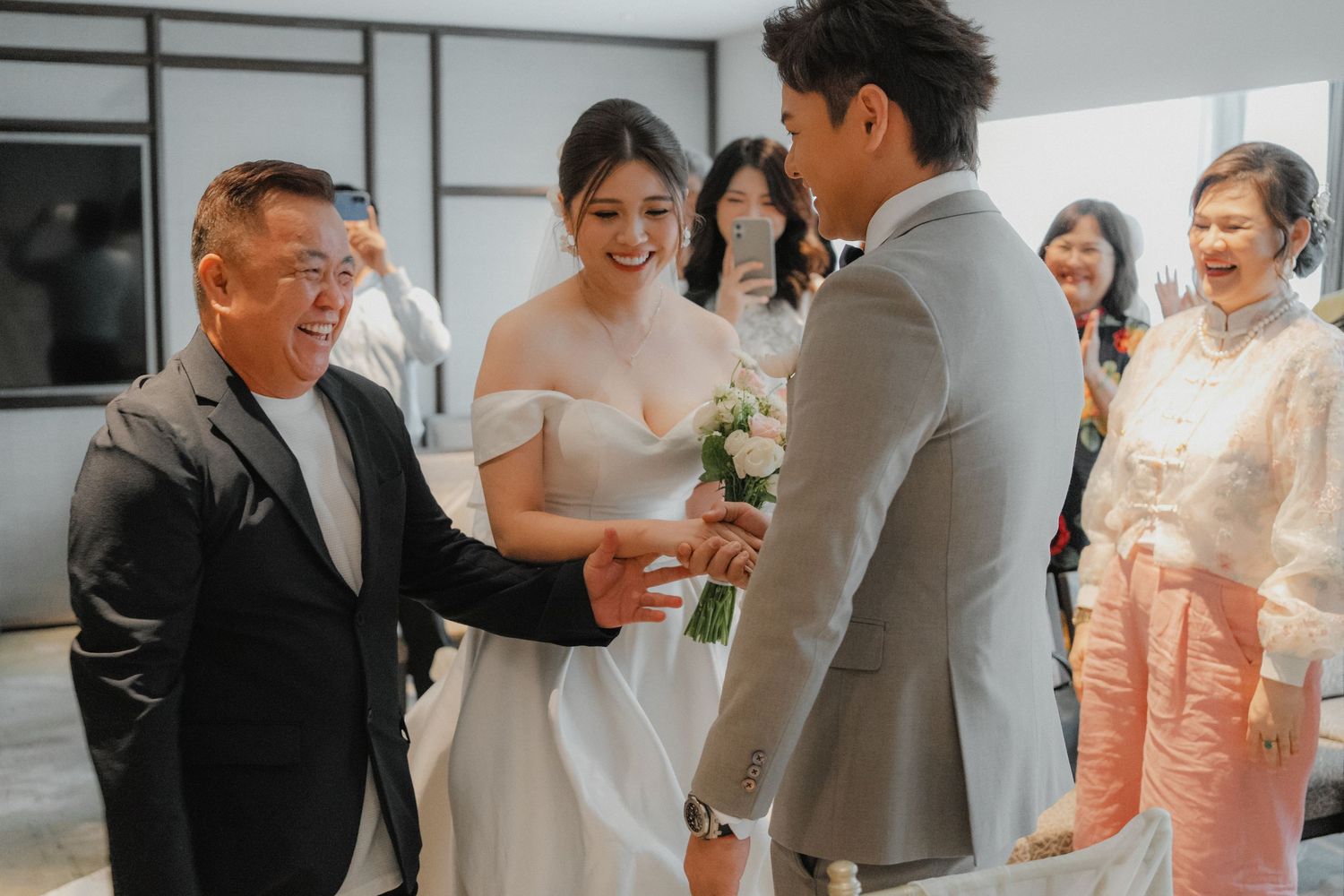 Intimate wedding ceremony moment captured indoors with guests watching emotional exchange.