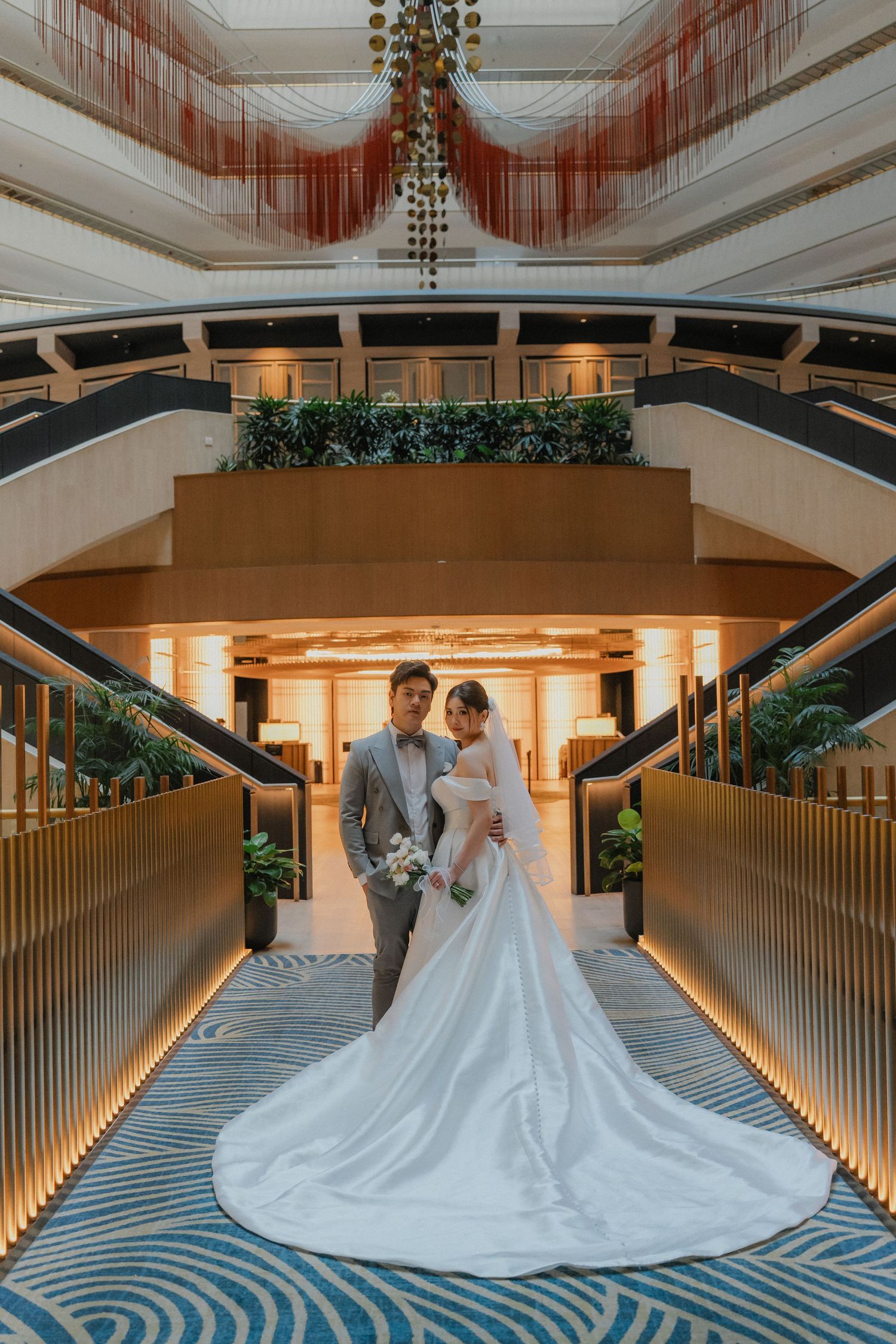 Stunning wedding venue hallway with warm lighting and geometric carpet leading to illuminated entrance.