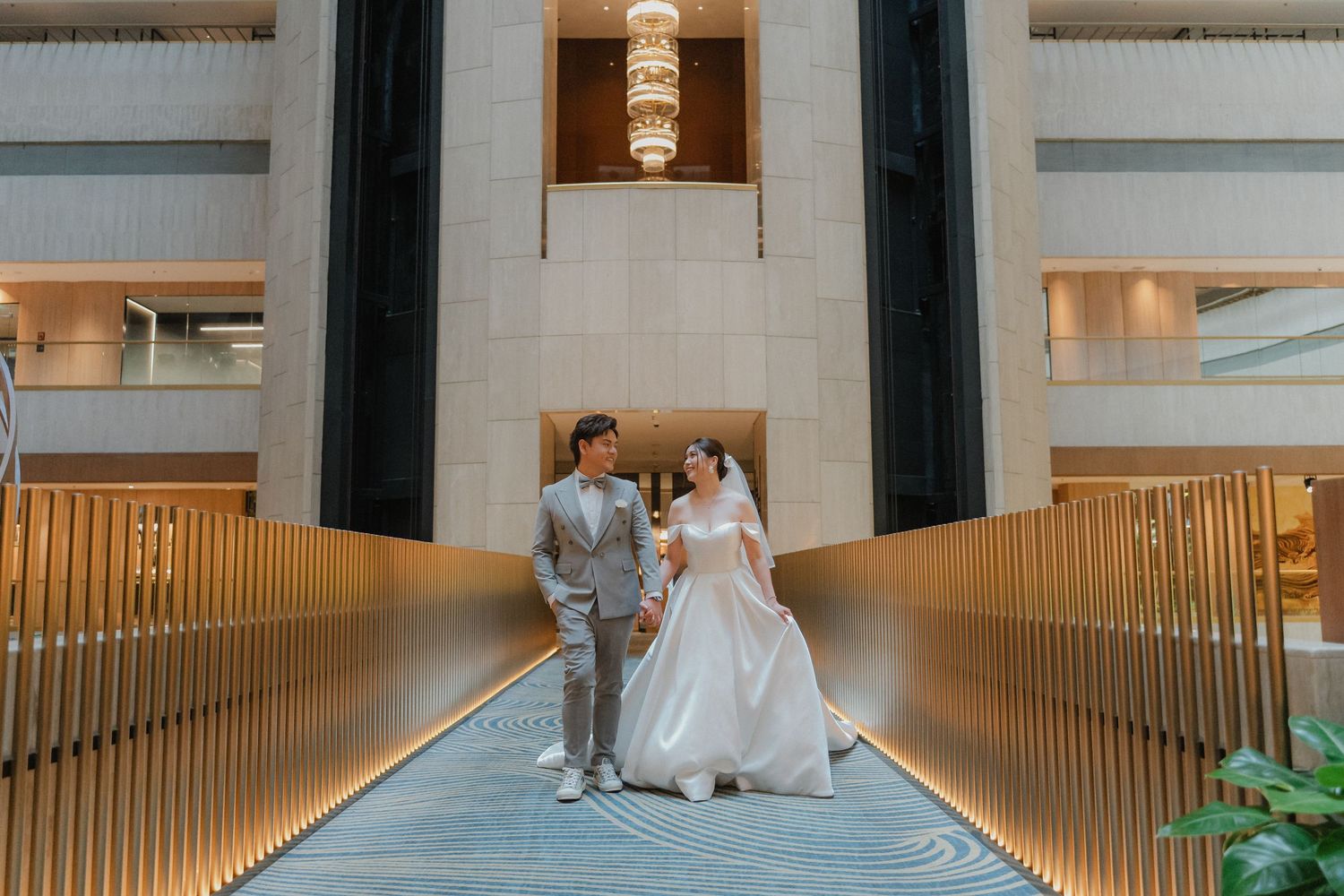 Modern wedding venue corridor with elegant wood panels and blue geometric flooring.