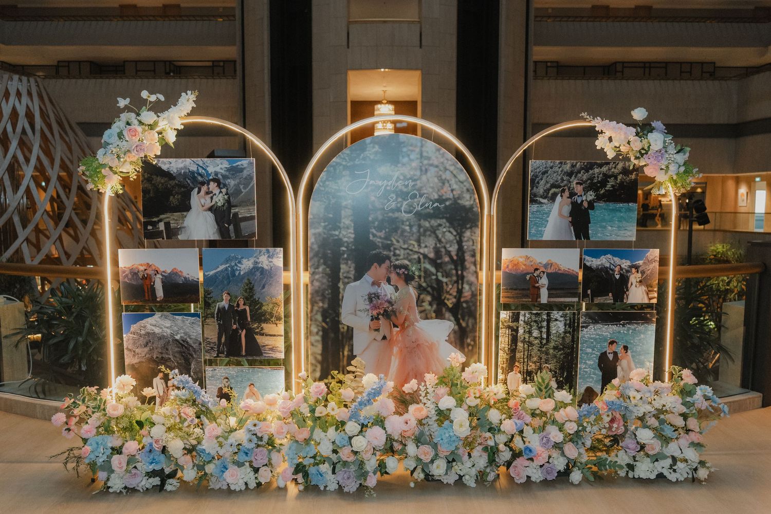 Wedding arch decorated with pastel blue and pink floral arrangements in an elegant indoor setting.