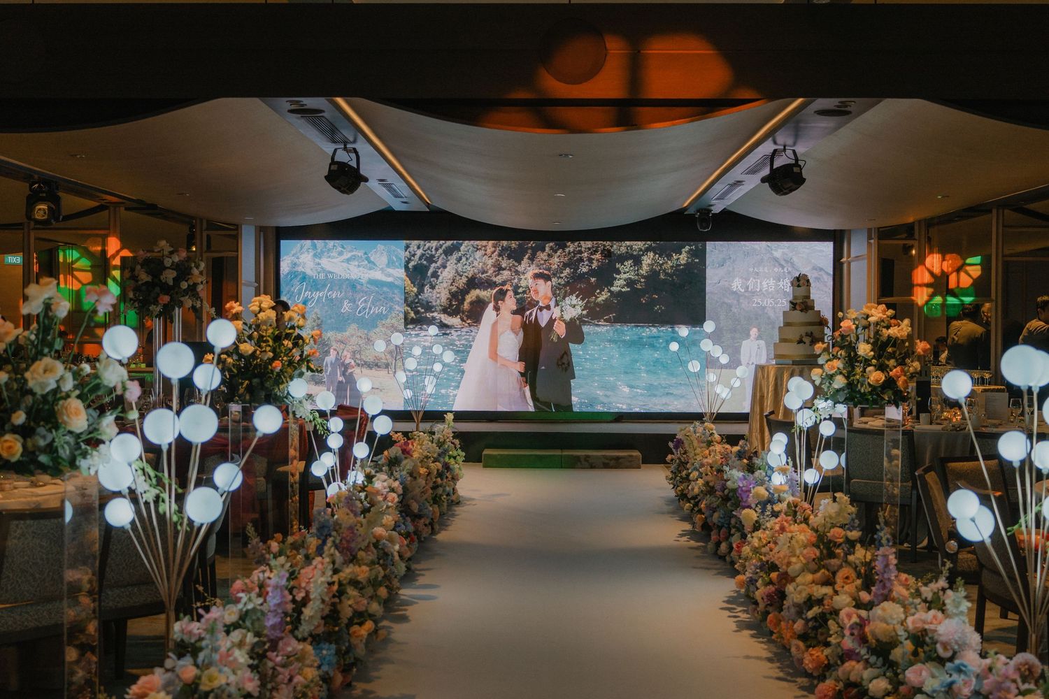 An elegant wedding ceremony setup with white balloons and floral arrangements lining the aisle.