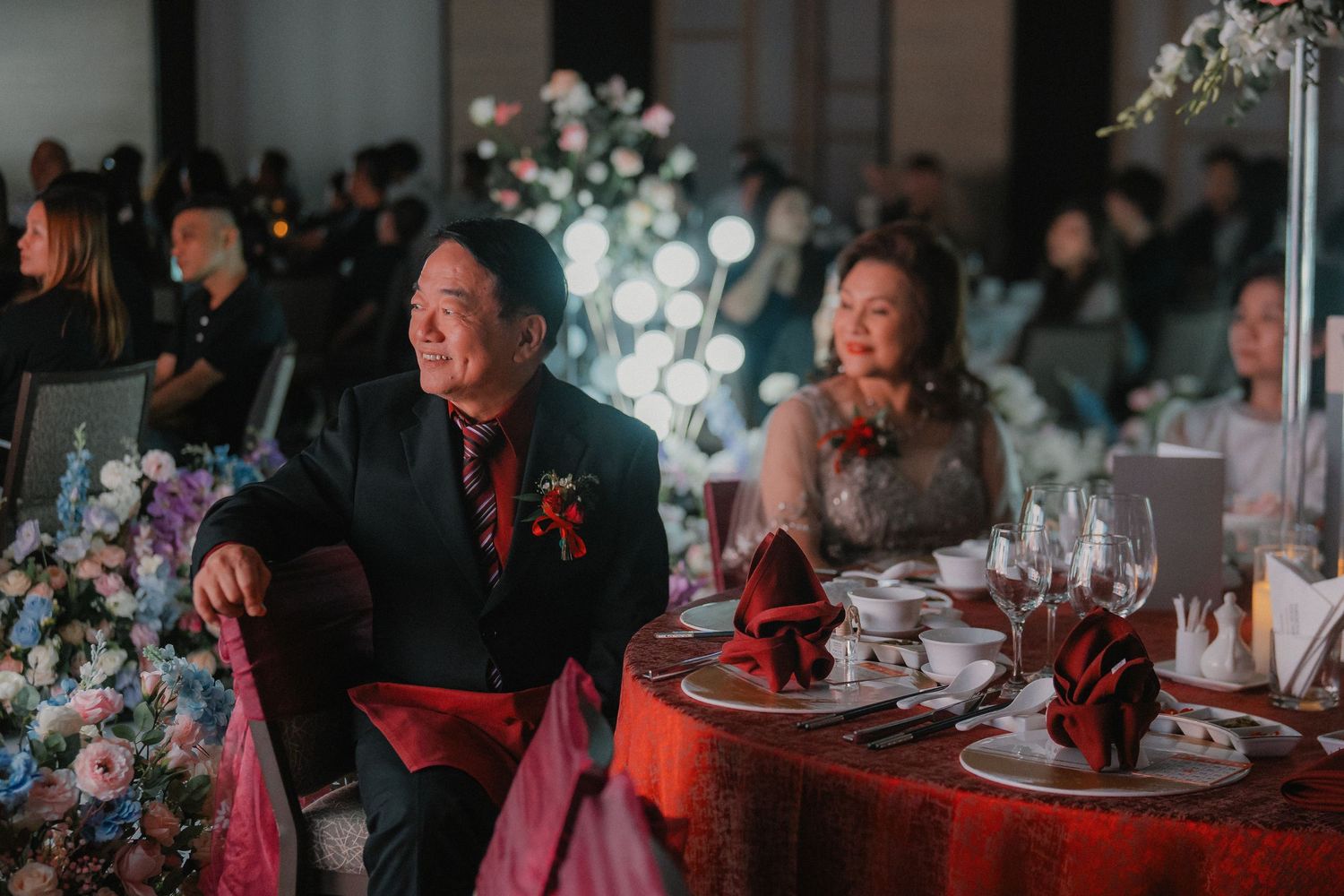 Formal dinner celebration with elegant table settings, balloons and floral decorations in a dimly lit banquet hall.