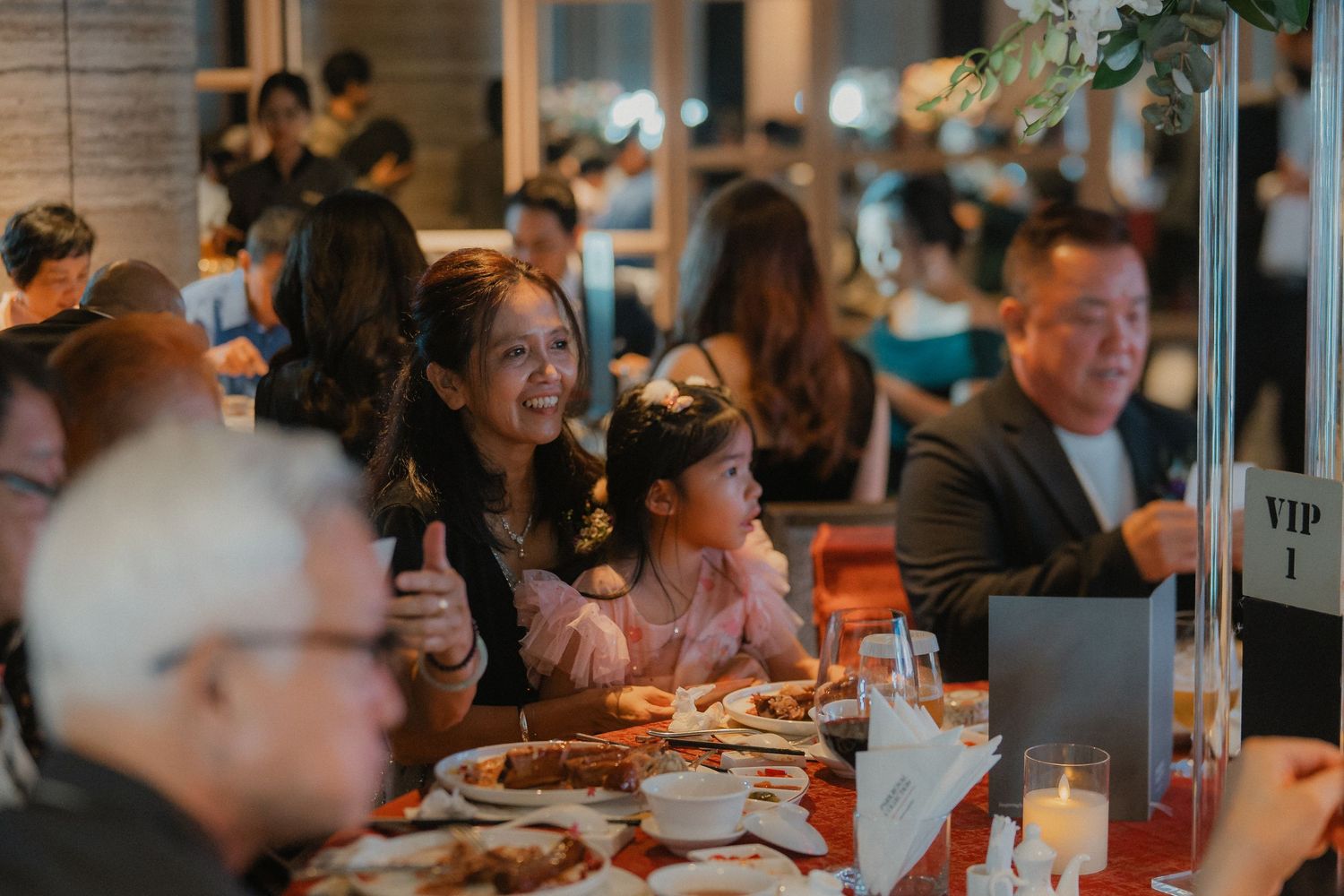 Wedding reception guests sharing laughter and conversations during dinner service.