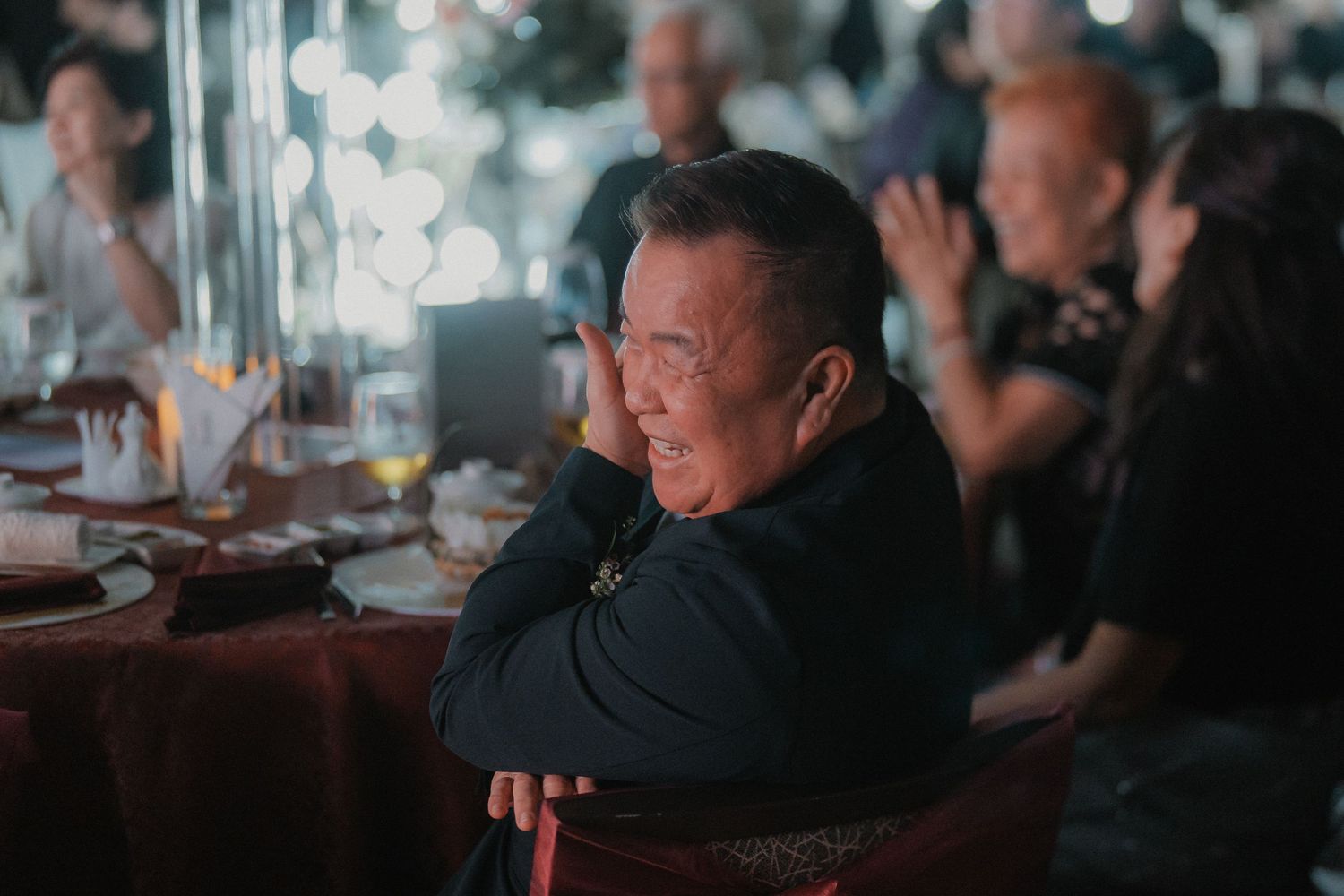 A guest at a wedding reception sitting in contemplation during the evening celebrations.