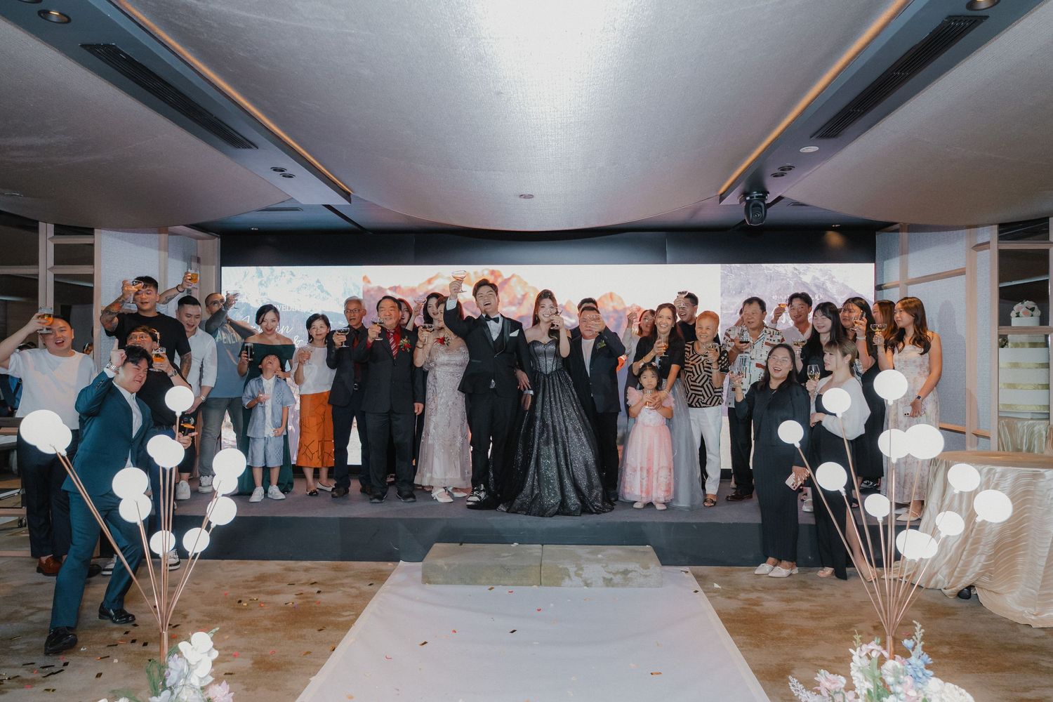 Wedding reception finale with guests gathered around decorated pathway for celebration.