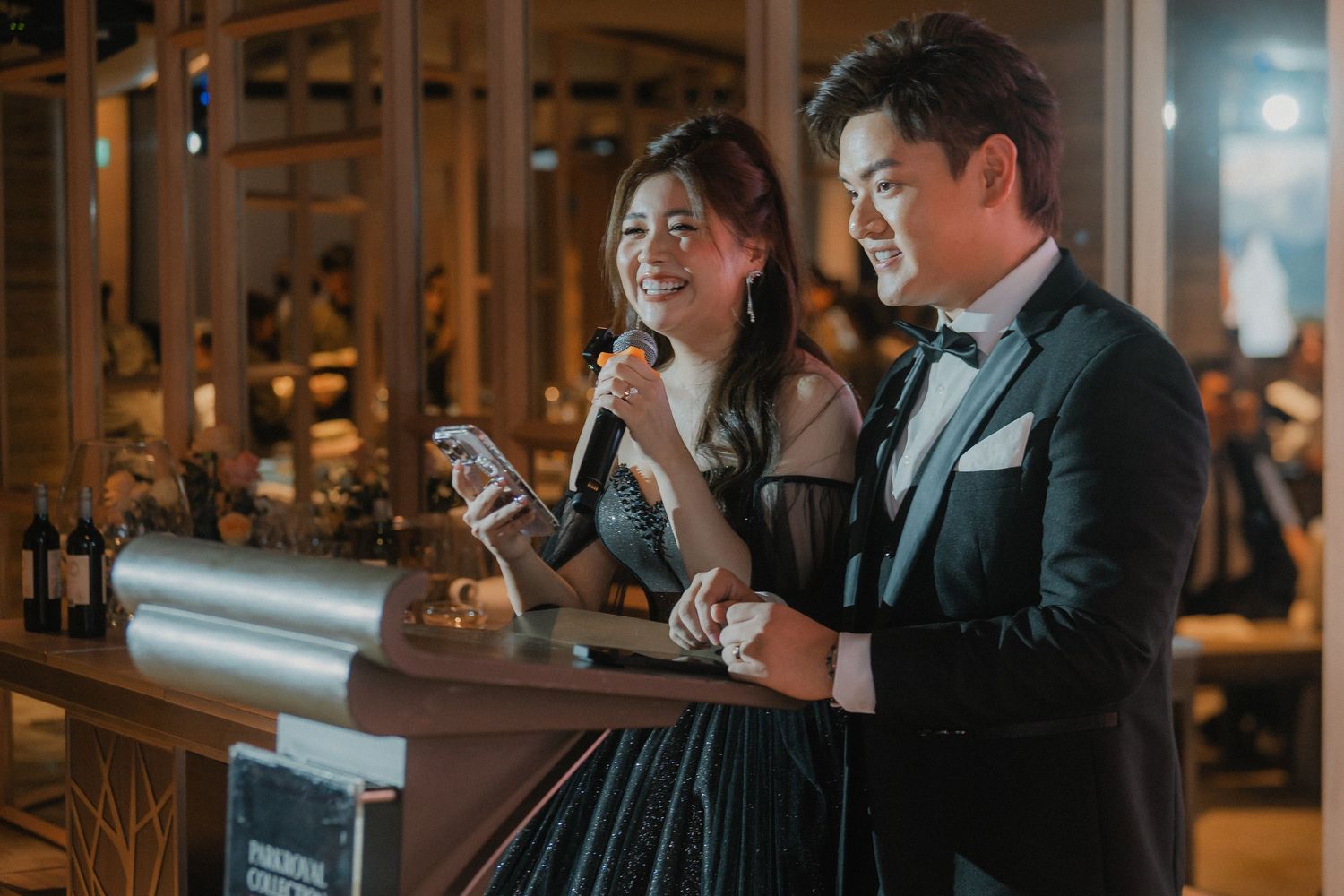 A couple shares a moment at the microphone during their wedding reception.