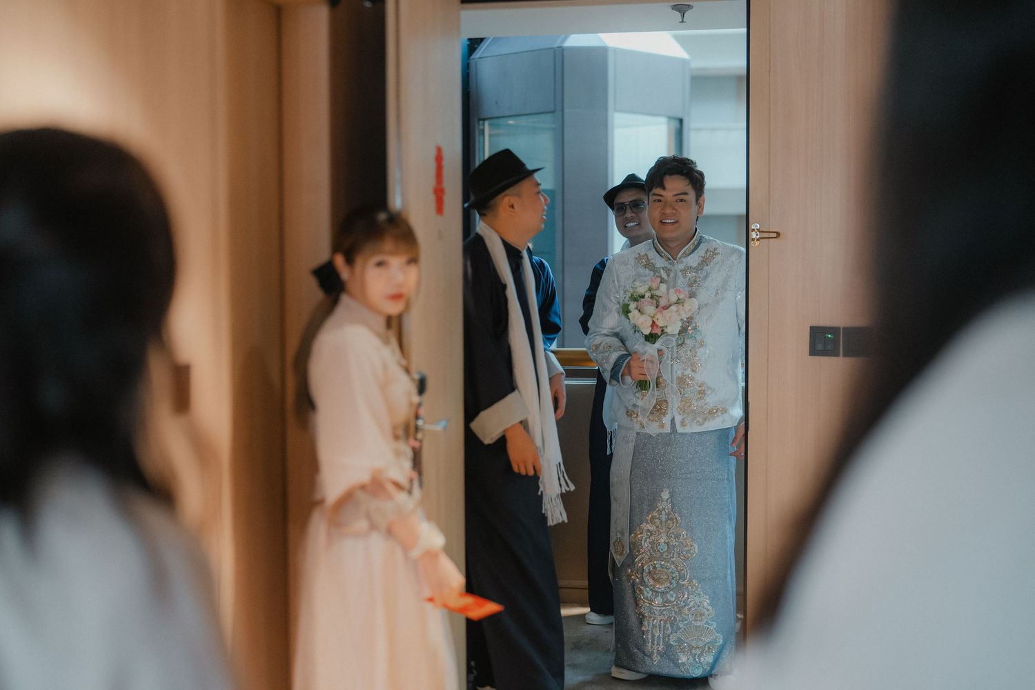 Wedding preparations taking place in a warmly lit hallway.