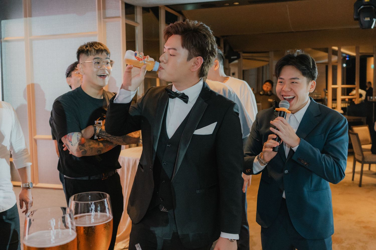 Wedding guests enjoy drinks and laughter during the reception celebration.