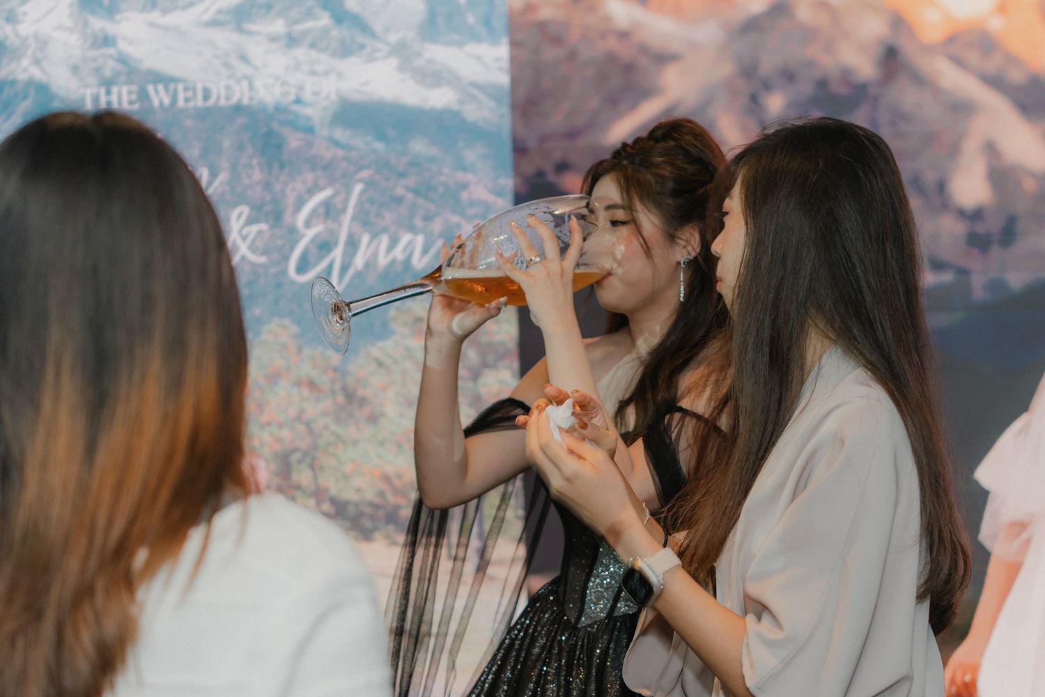 Wedding singers performing on stage against a mountain backdrop during an outdoor celebration.