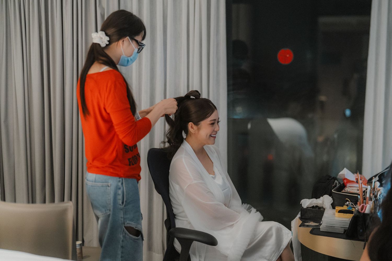 Behind the scenes preparation with styling taking place in a bright modern room.