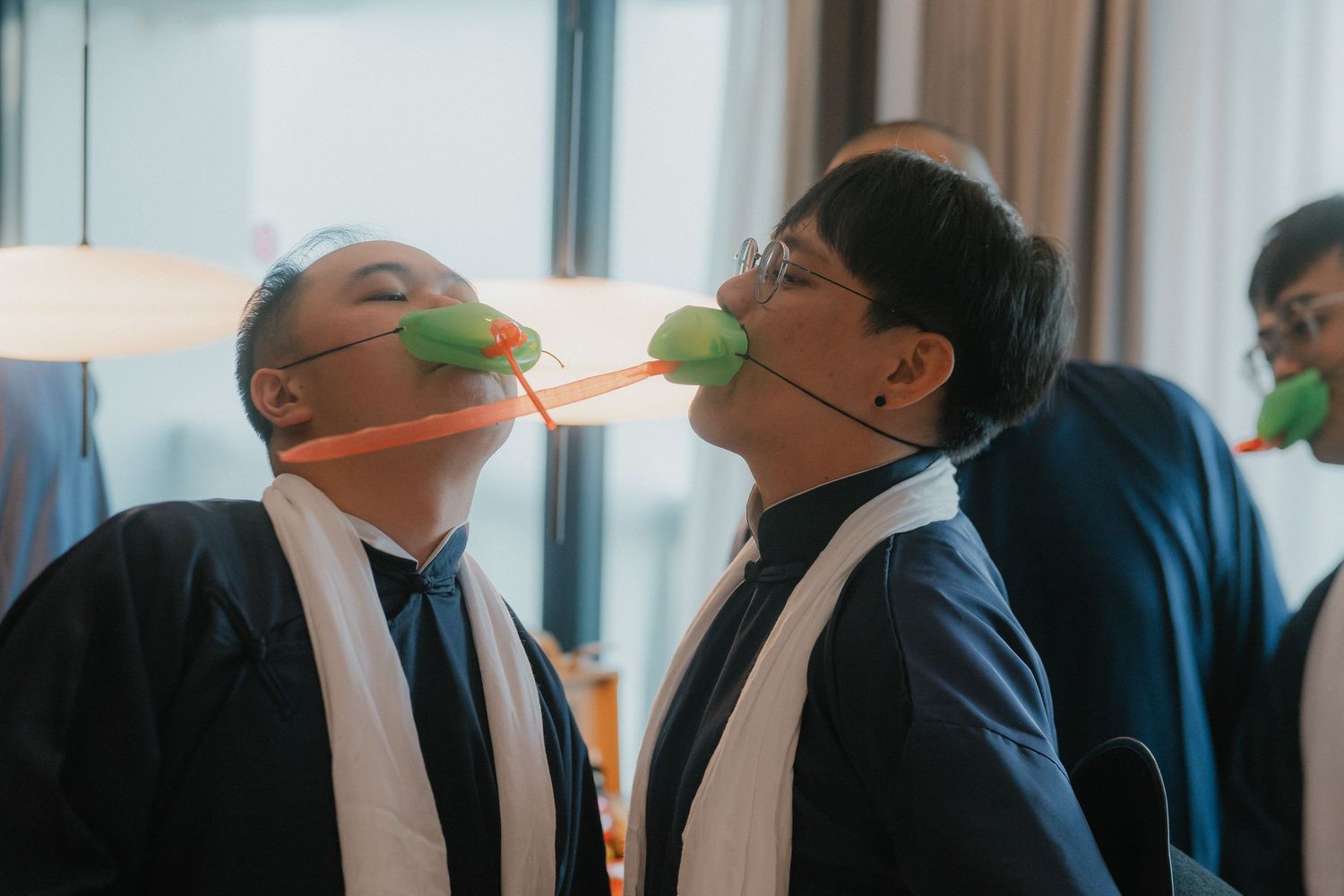 Wedding party members playing balloon games in formal attire.