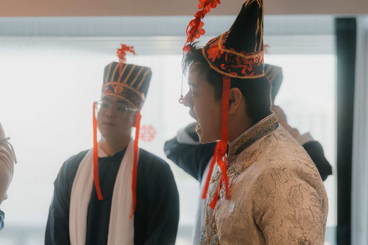 Traditional celebratory gathering with attendees wearing ornate traditional headpieces.