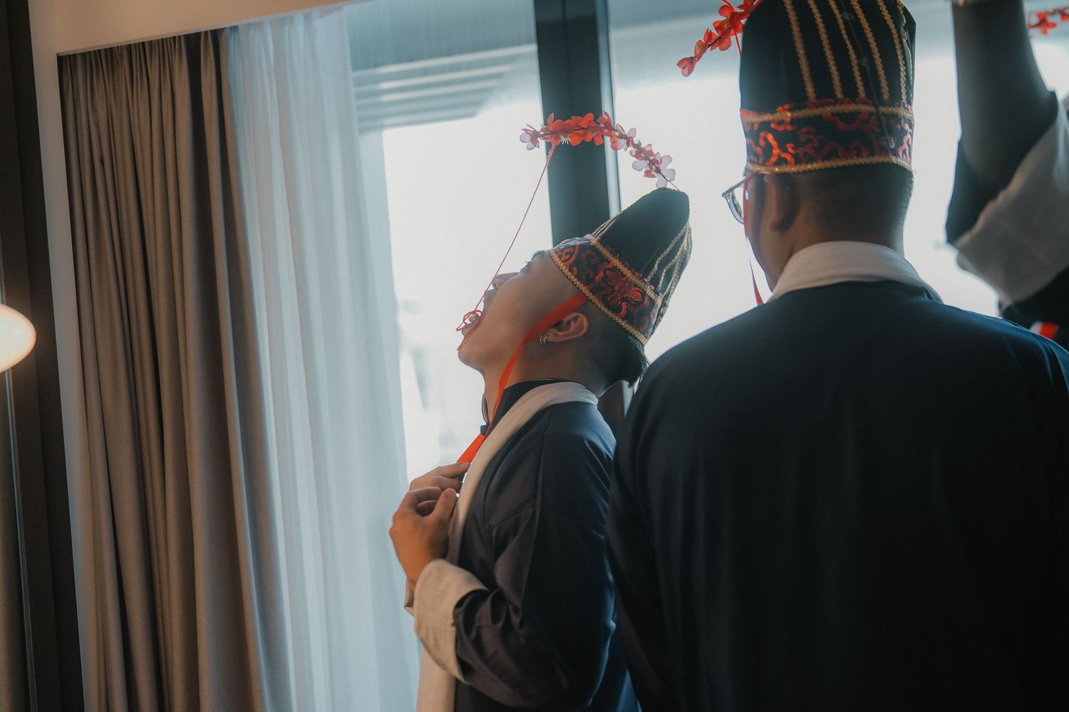 Guests mingling at an elegant indoor wedding celebration with natural light streaming through windows.
