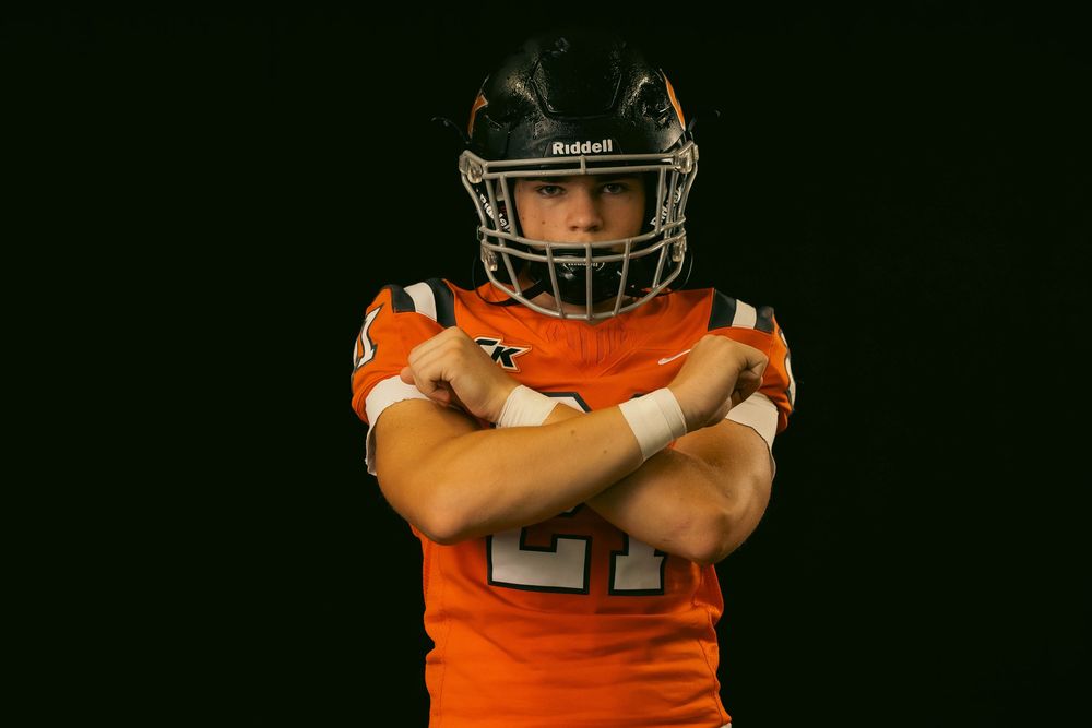 Athletic figure in orange and white uniform performs expressive motion poses on dark background.