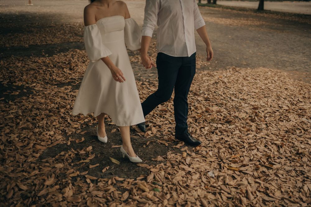 Couple walking on leaf-covered path showing romantic connection.