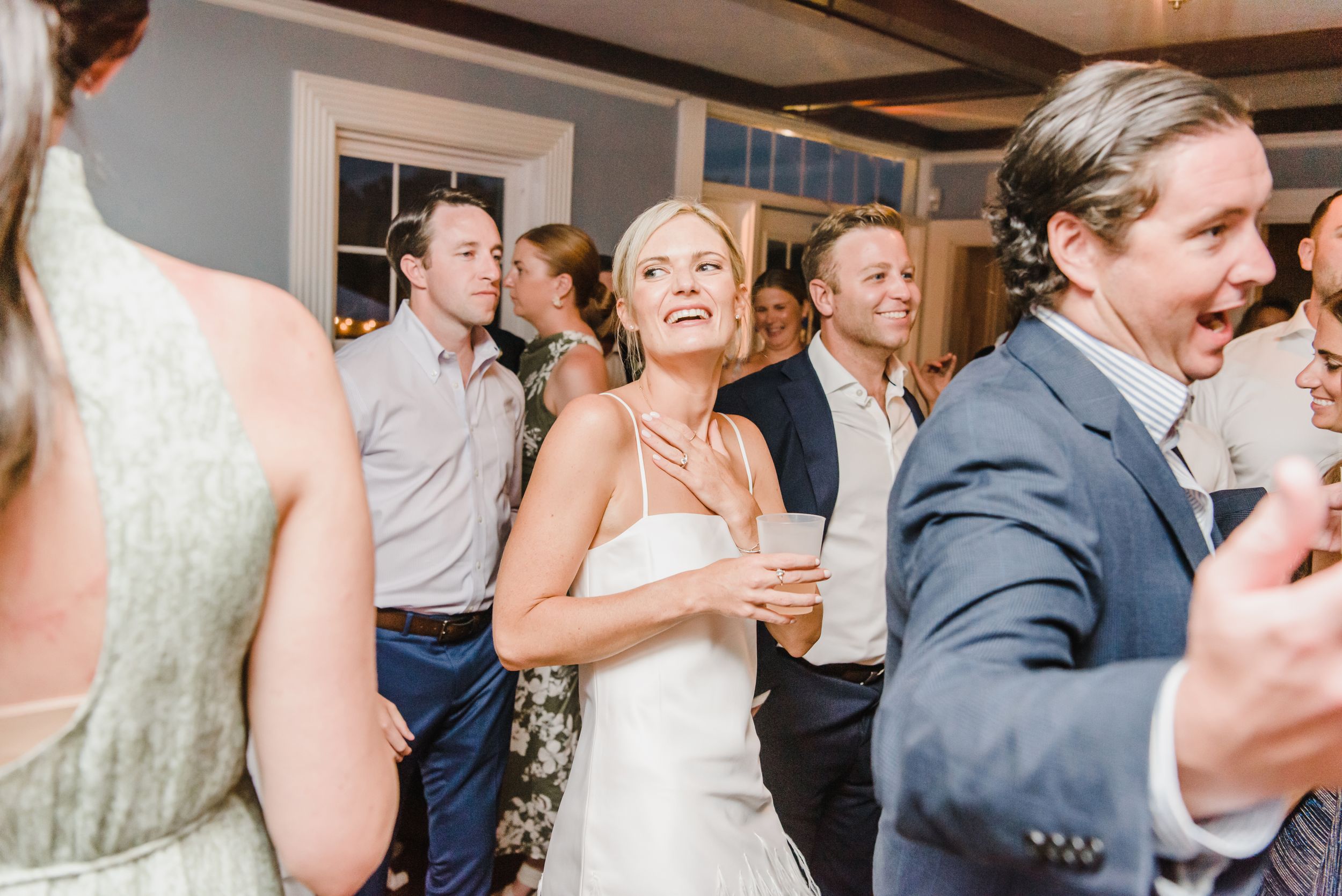 Wedding reception guests dancing and celebrating together on the dance floor during an indoor evening celebration.