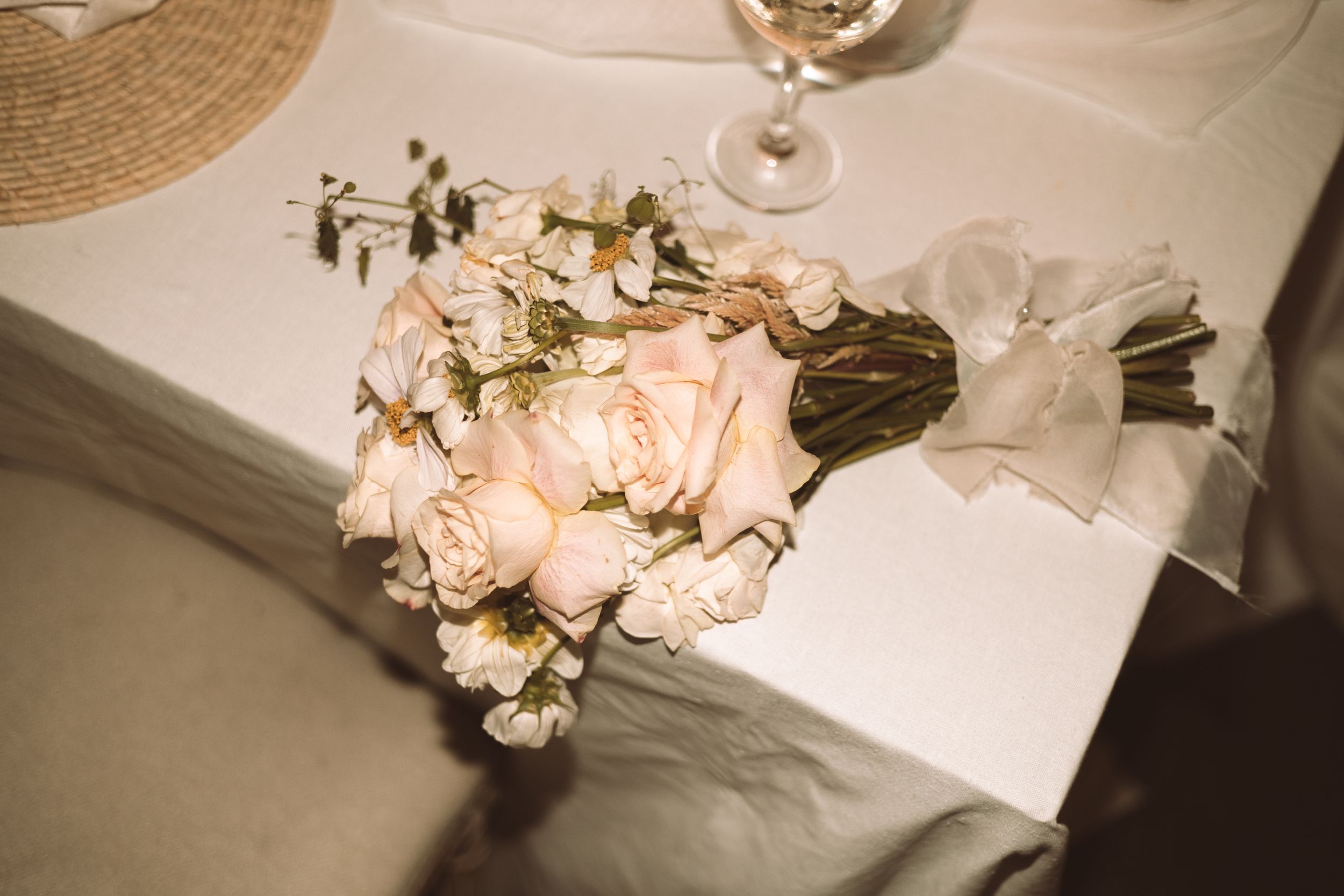 Elegant table setting with pink roses and glowing candlelight at a wedding reception.
