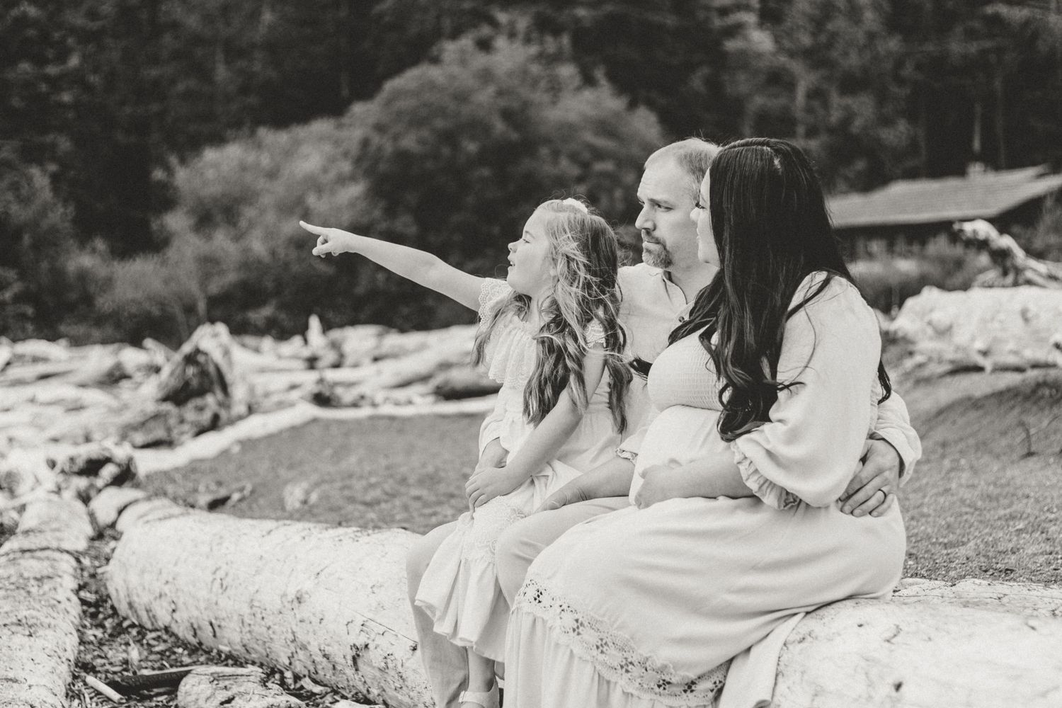 Black and white photo of joyful moment between parent and child on rocky beach.