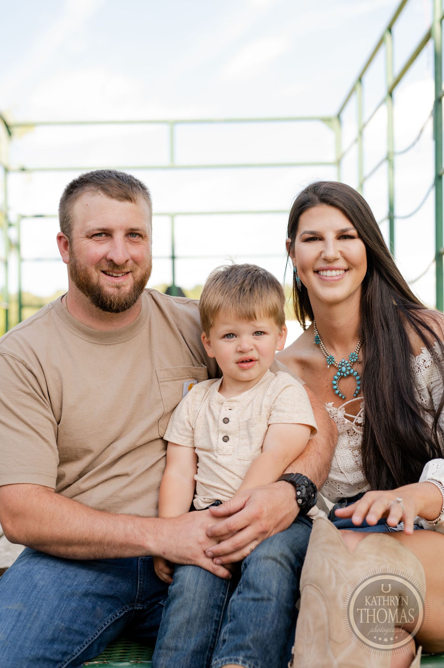 Family portrait taken on outdoor metal platform in warm sunlight.