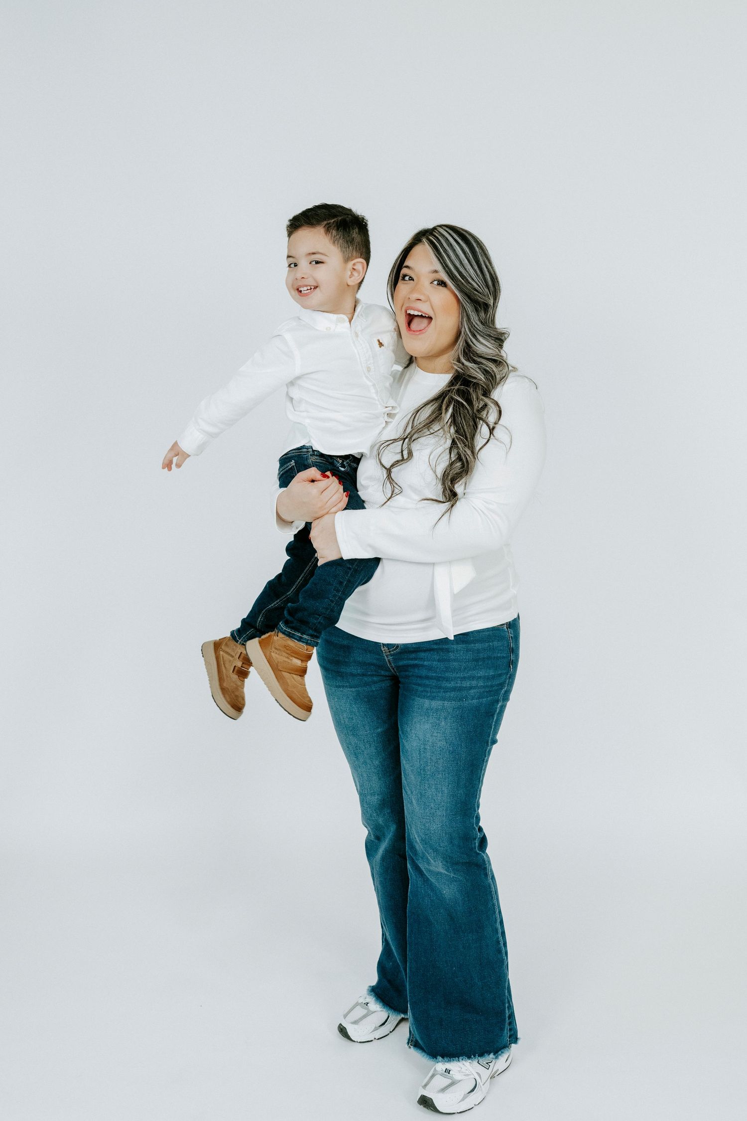 Candid moments of family play and laughter captured against a clean white studio background.