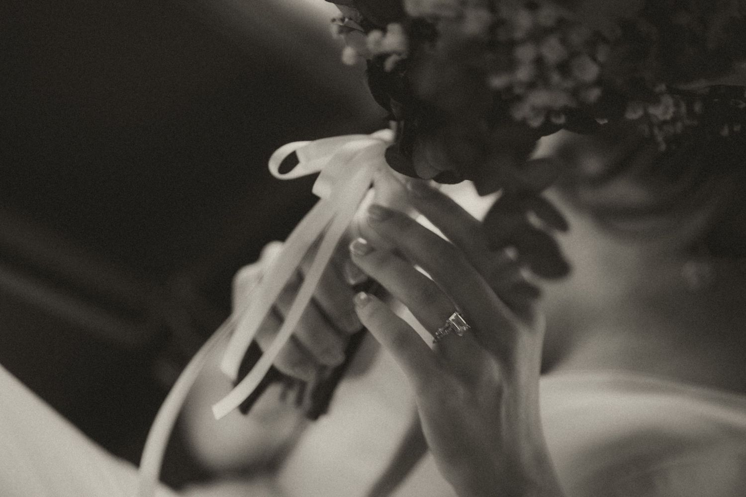 Black and white close-up photograph of hands holding a flute or woodwind instrument.