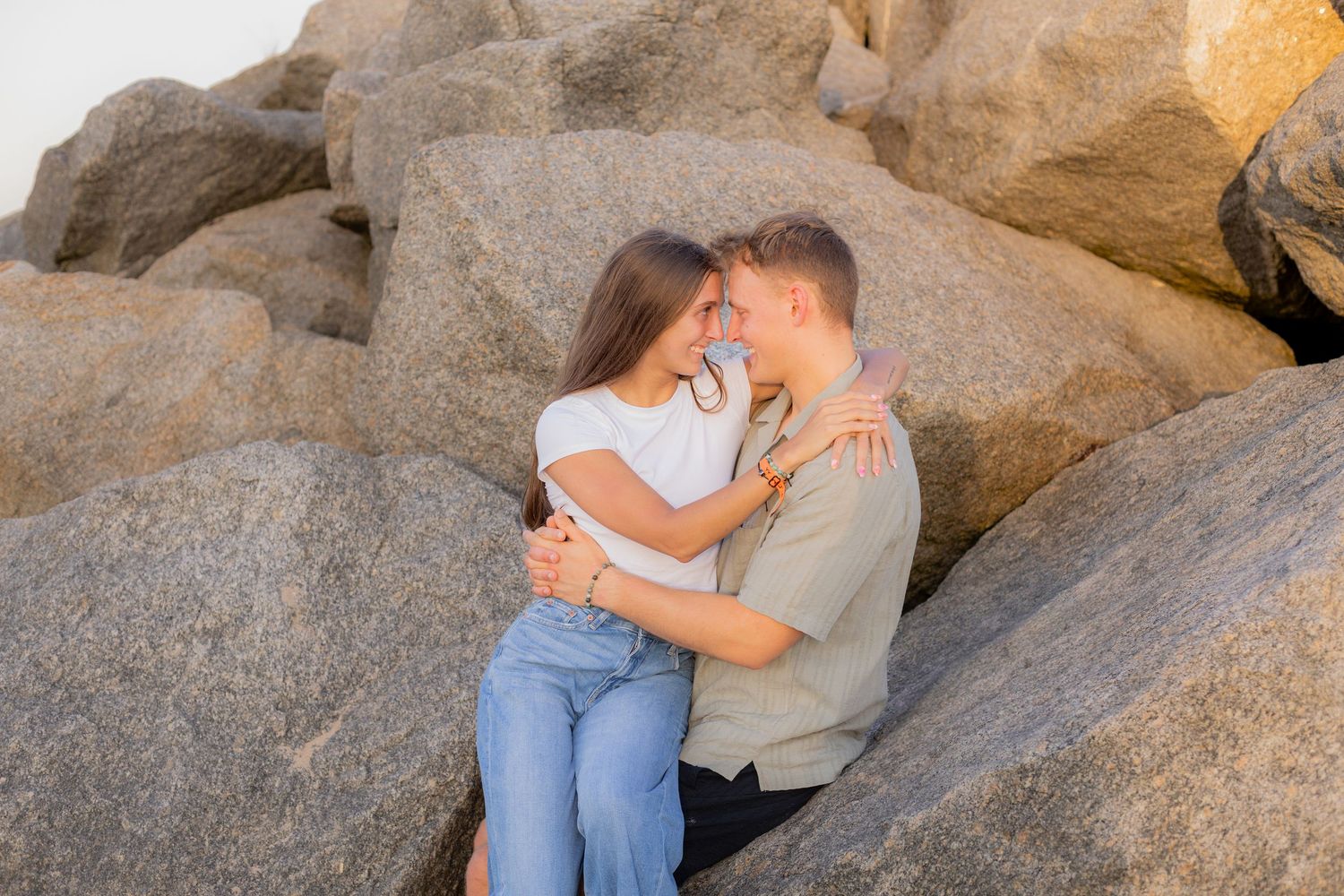 Couple embracing on rocks at beach taken by Fort Lauderdale Photographer