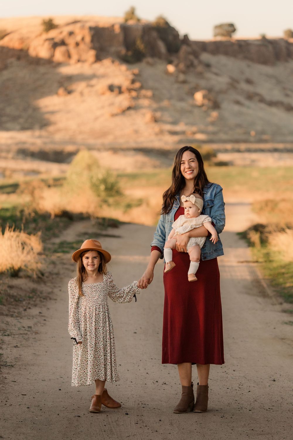 Family poses together on desert path during sunset.