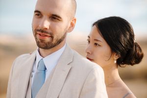 Close up portrait of couple smiling together against blurred desert landscape background.