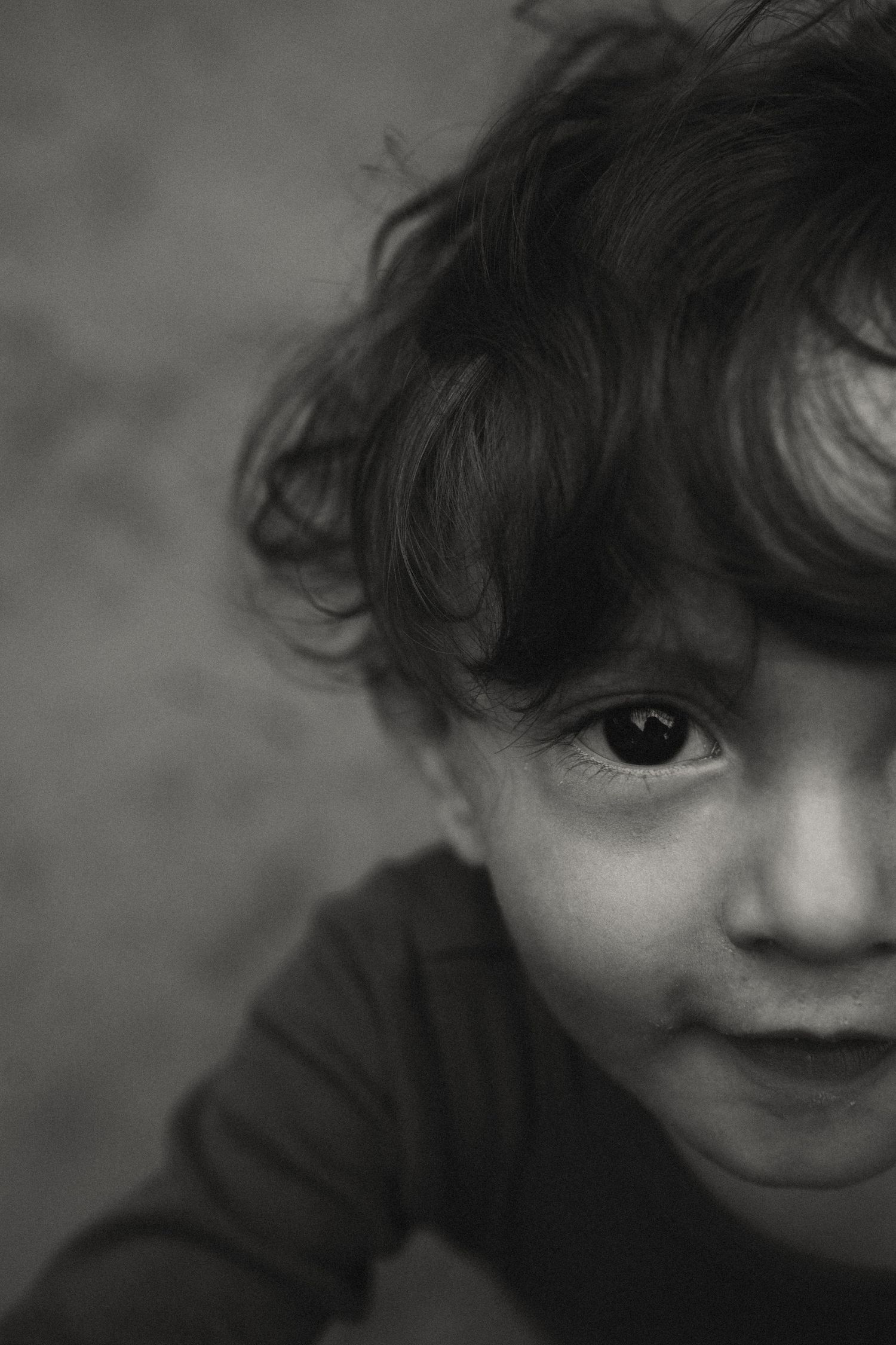 Close-up portrait sequence showing playful expressions and curly hair against a dark background.