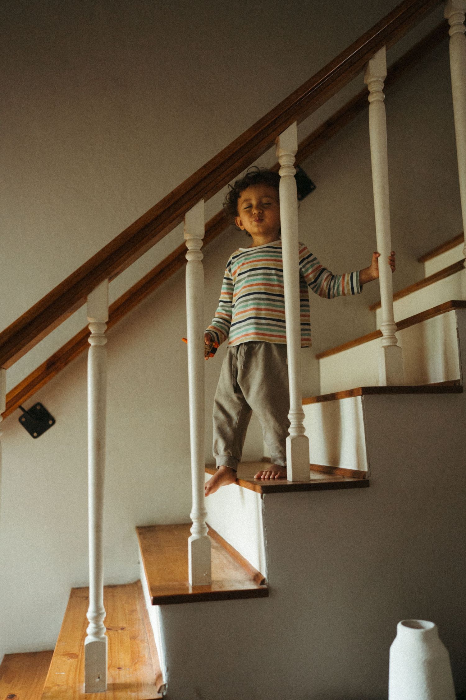 Sequential images of someone climbing wooden stairs indoors.