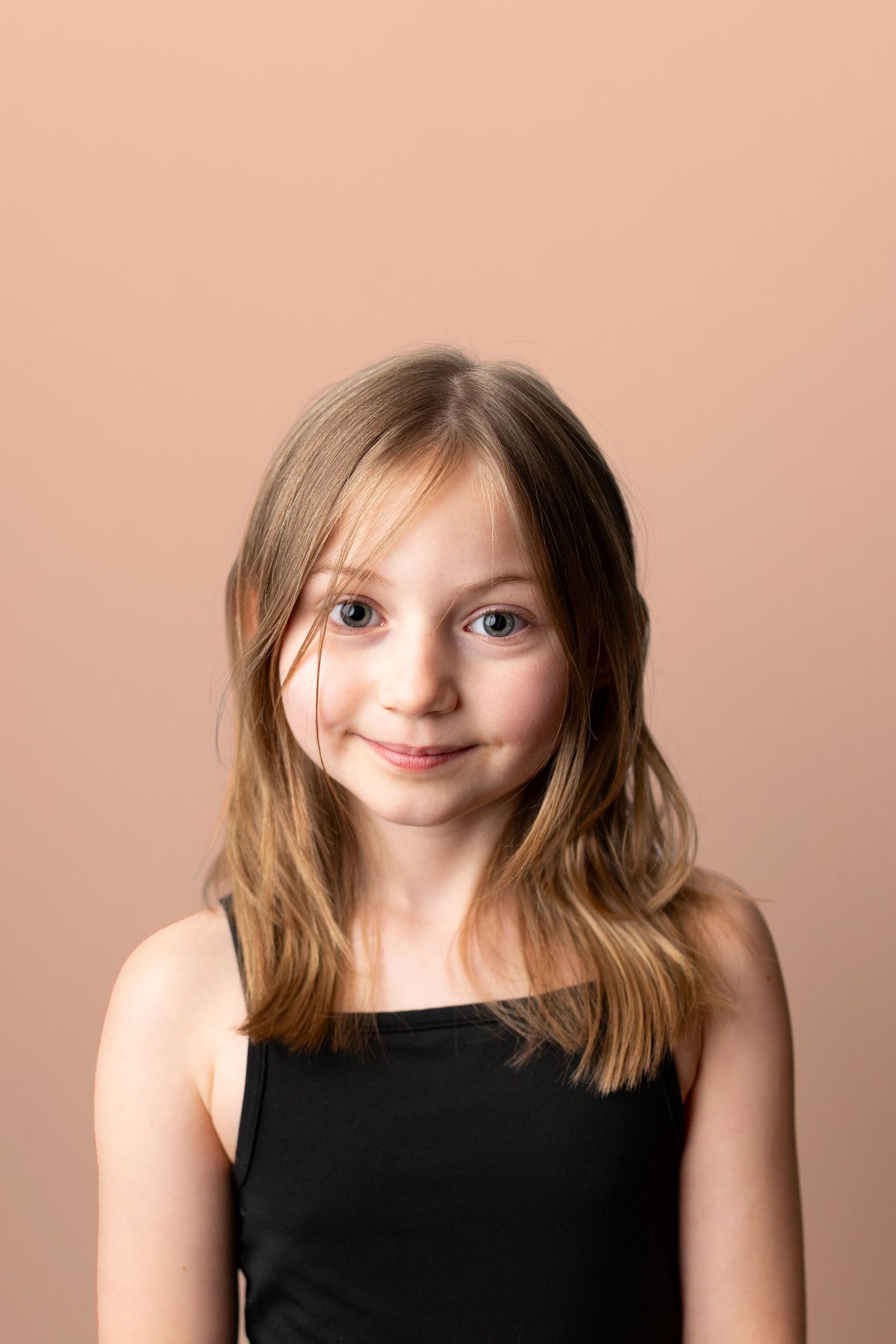 A series of portrait shots showing playful expressions against a peachy pink background.