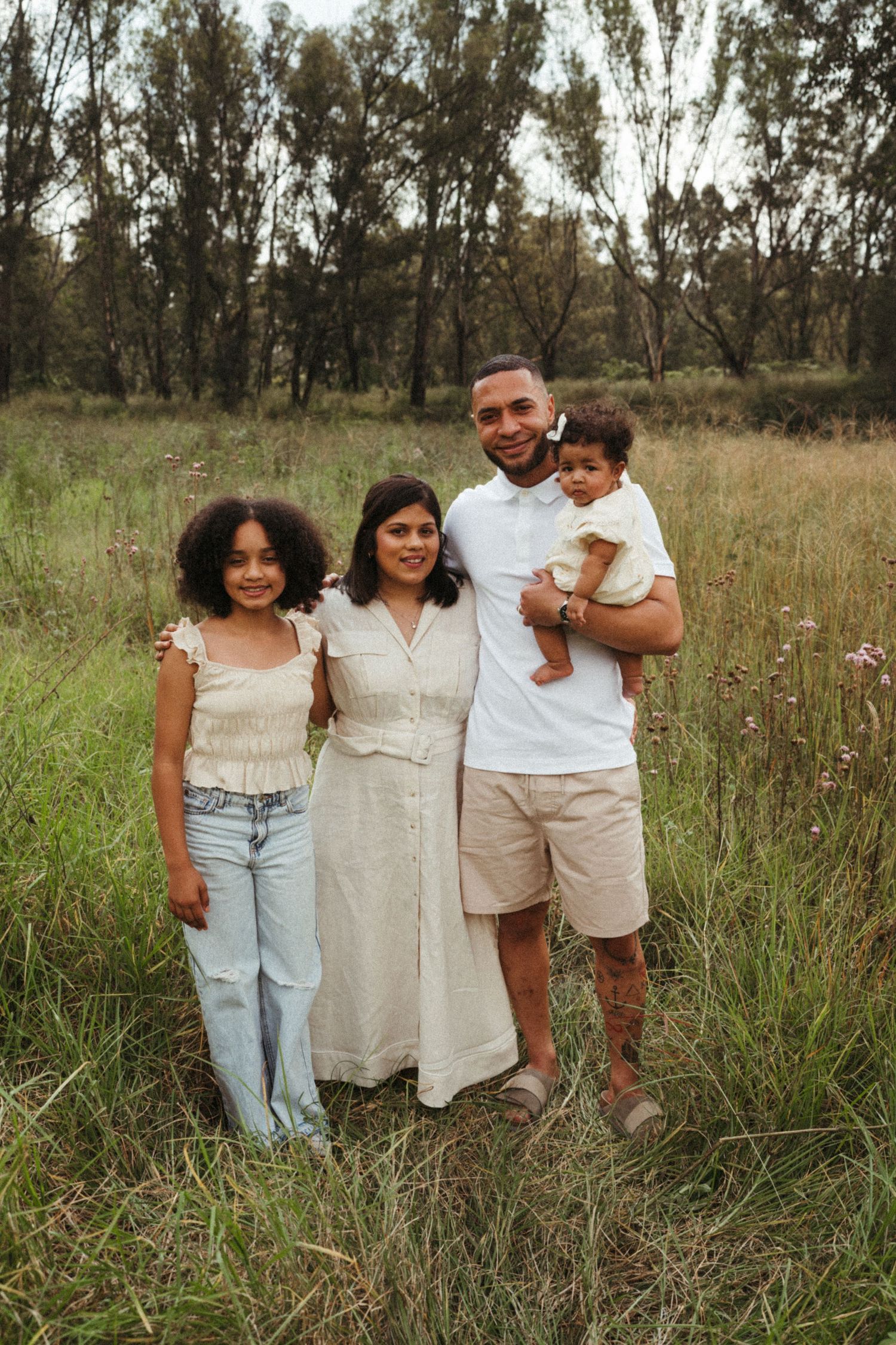 Candid family portrait showing natural interactions in a rustic outdoor setting.