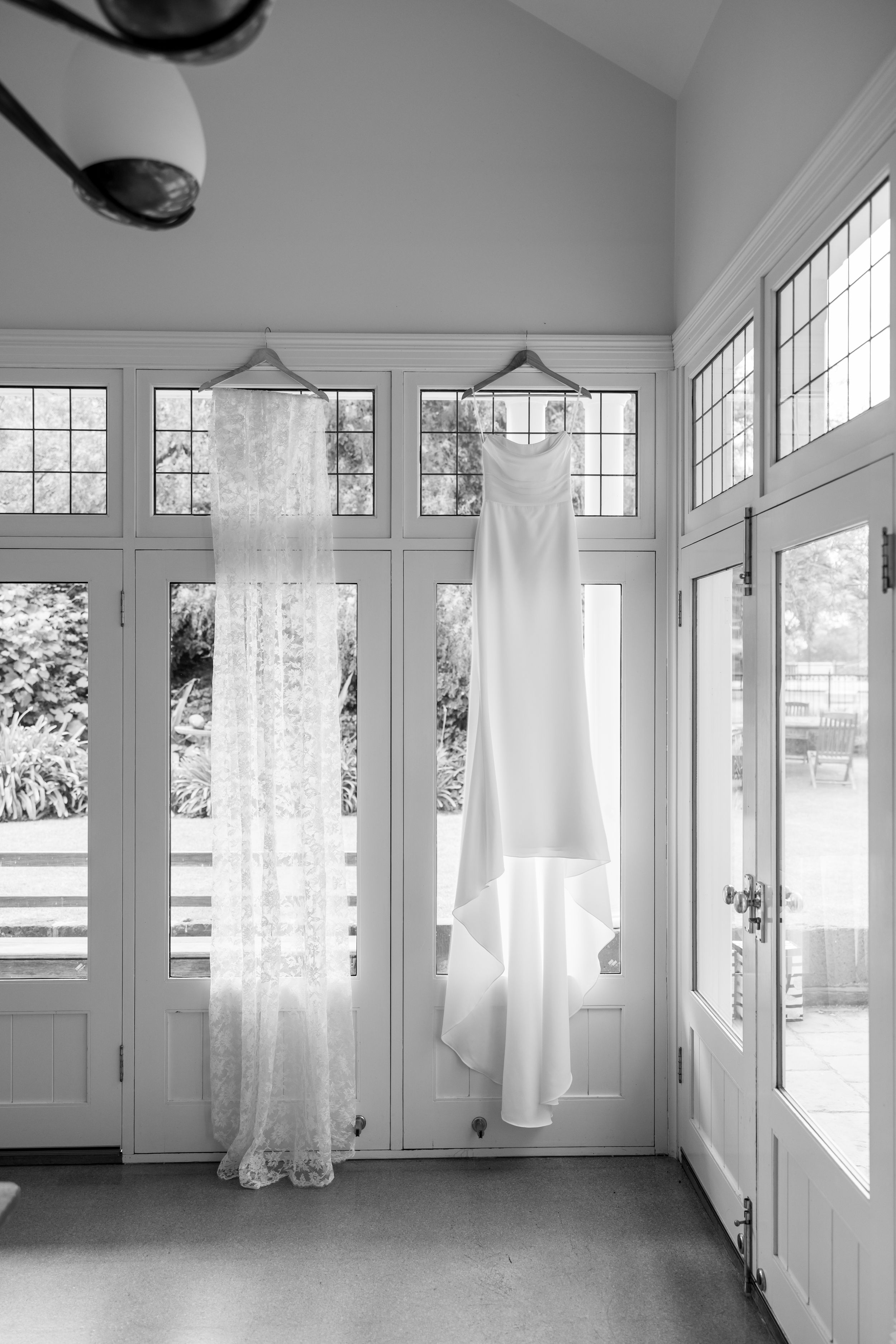 A bright, airy room with white curtains, multiple windows, and natural light streaming in.