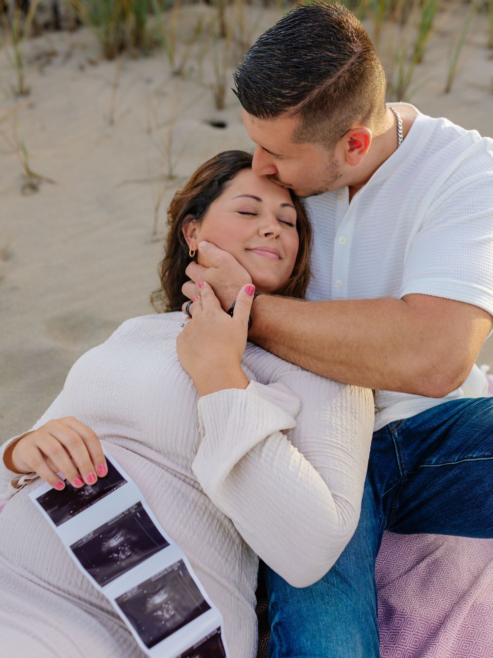 Intimate beach pregnancy announcement photoshoot with ultrasound photos.