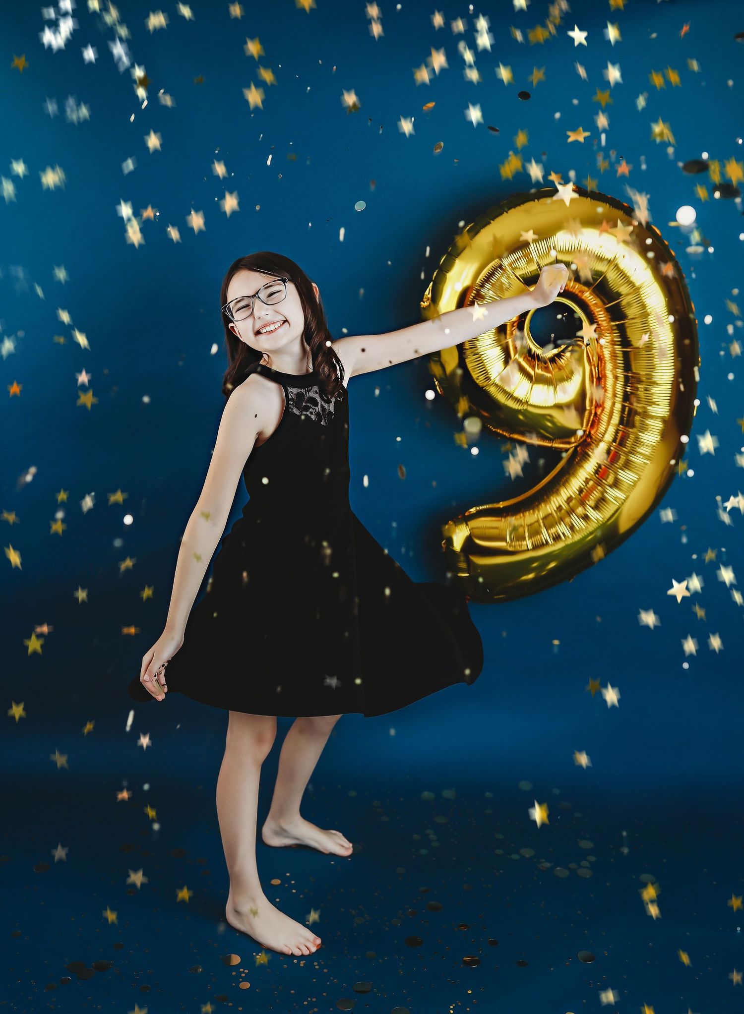child smiling with arms up with a balloon nine in the background
Best child photographer, Peoria, IL.