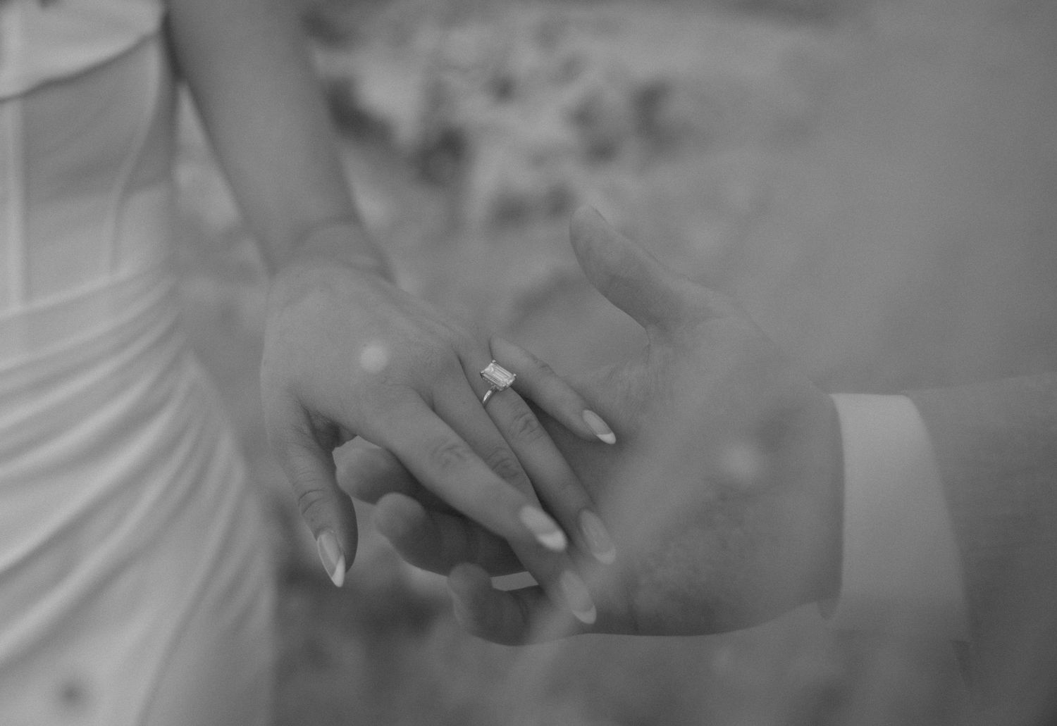 Close-up black and white sequence showing hands exchanging wedding rings during a marriage ceremony.