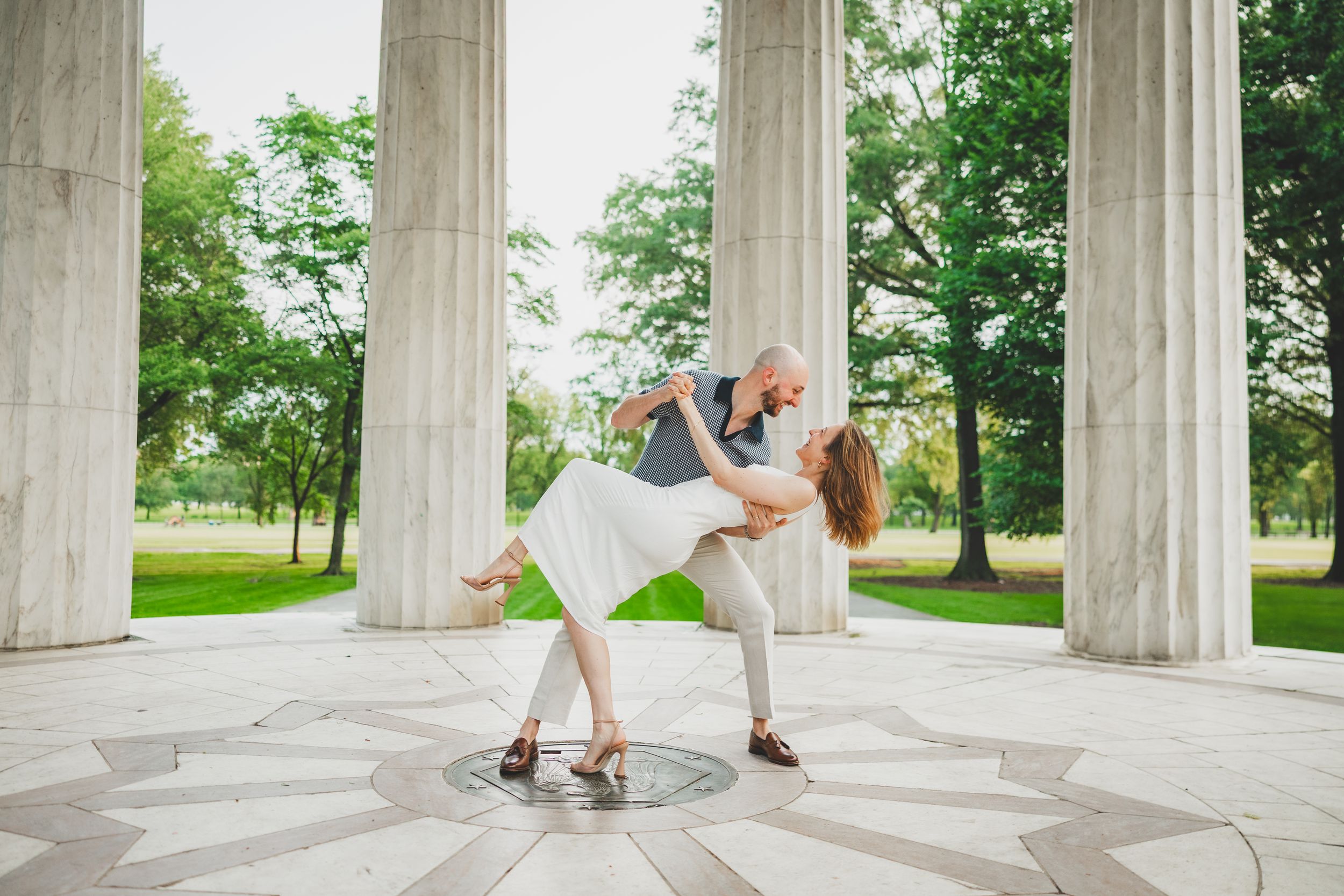 Romantic dip and kiss pose beneath the marble pavilion at the DC War Memorial