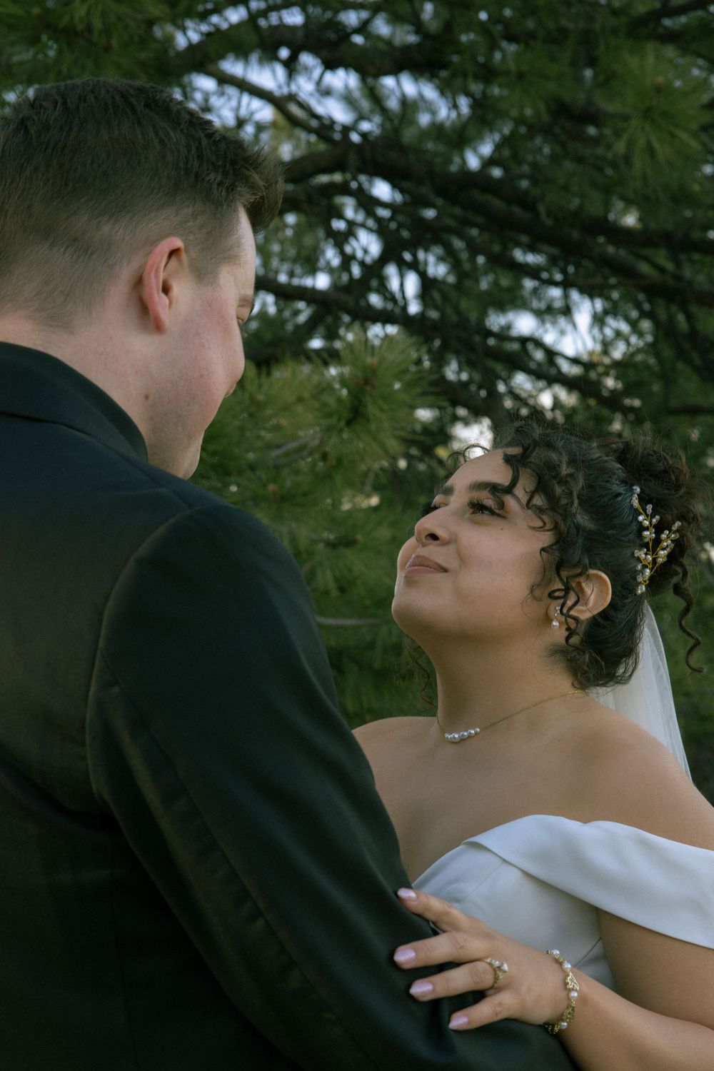 Newly married couple embracing during wedding portraits in Boulder, Colorado, surrounded by natural scenery.