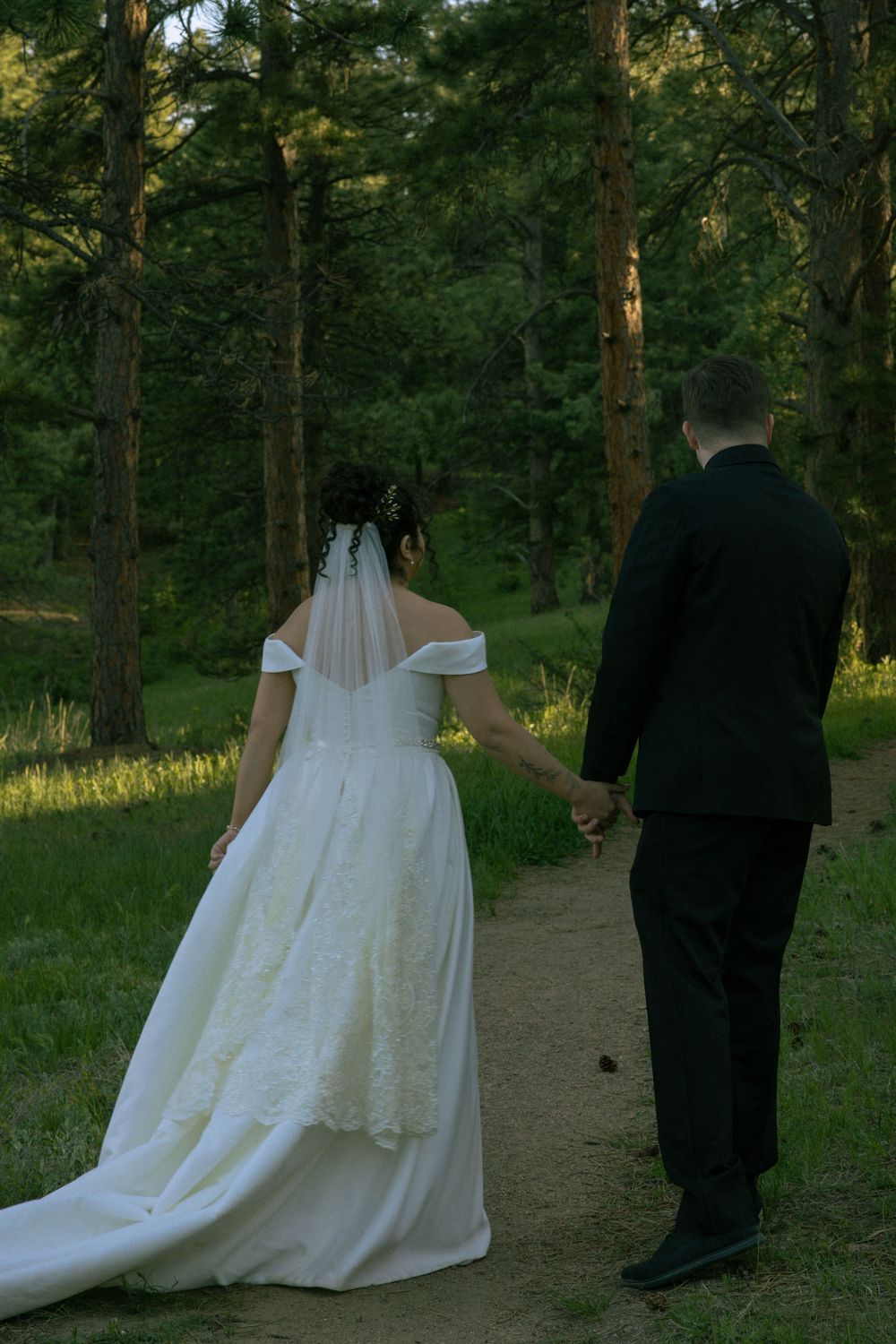 Couple holding hands during wedding portraits with mountain views in Boulder, Colorado.