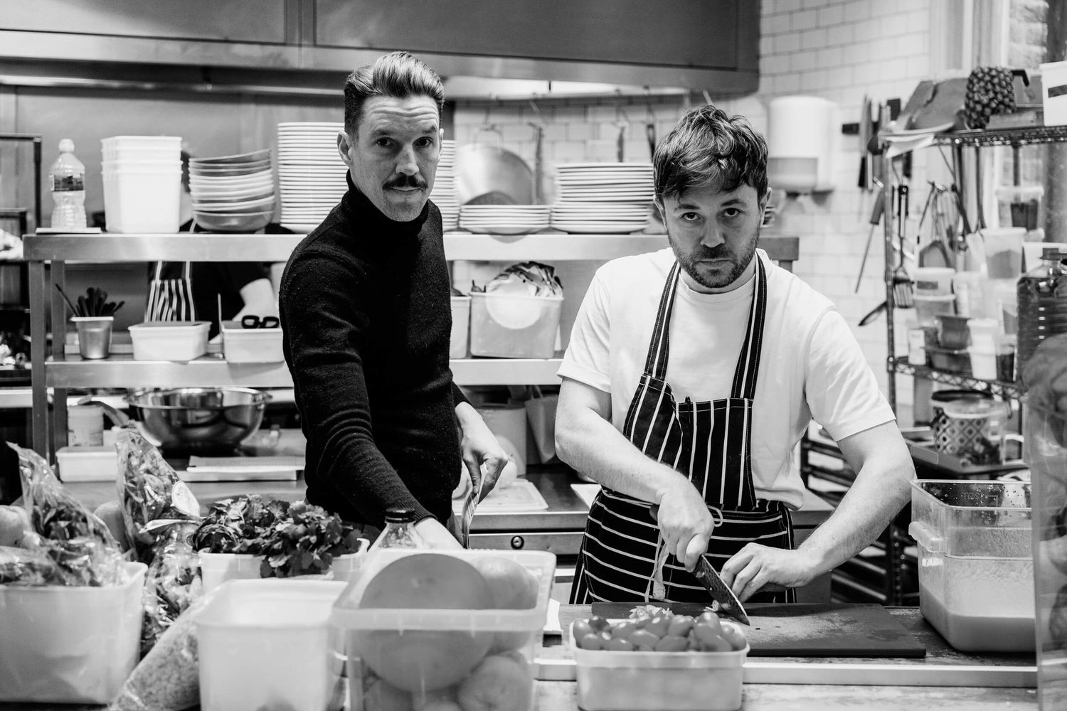 Black and white photo series showing chefs working in a busy restaurant kitchen preparing meals.